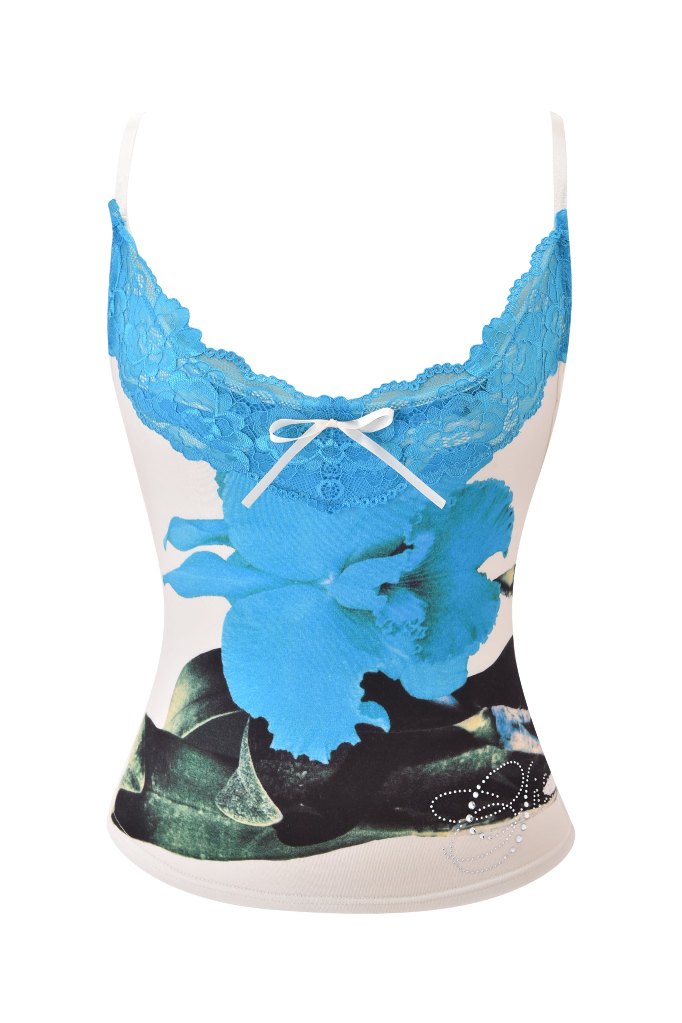 The ADELLA TOP - BLUE by I.AM.GIA features a fitted floral cami design with blue lace trim at the neckline, a white bow accent, and a bold blue print over a white background with black and green details near the hem.