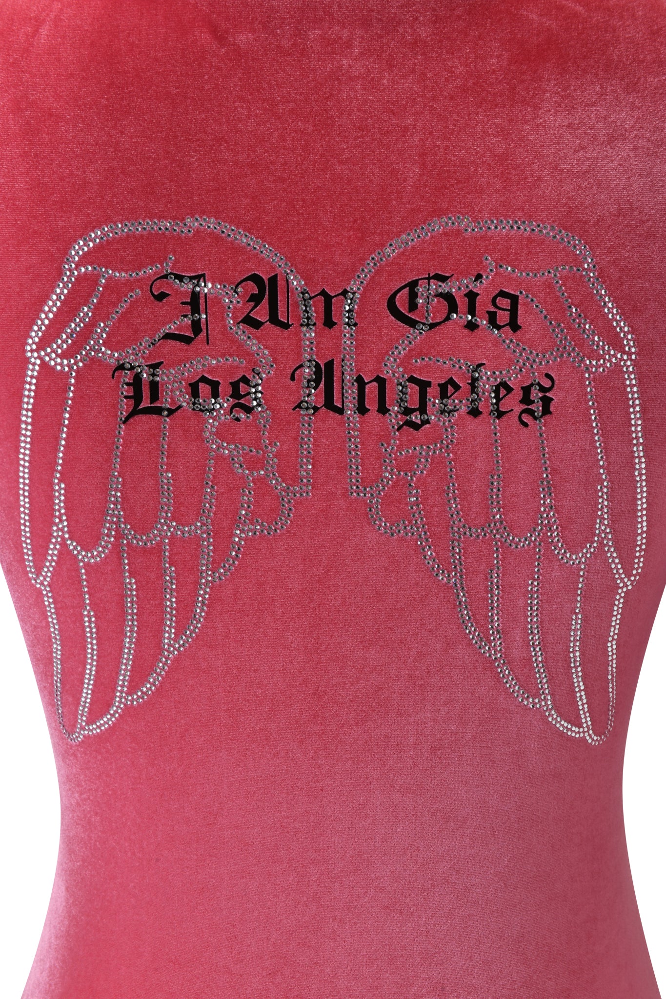A close-up of the BLARE VELOUR POCKET HOODIE in pink by I.AM.GIA, featuring diamanté angel wings and "I Am Gia Los Angeles" in bold black gothic font across the back.