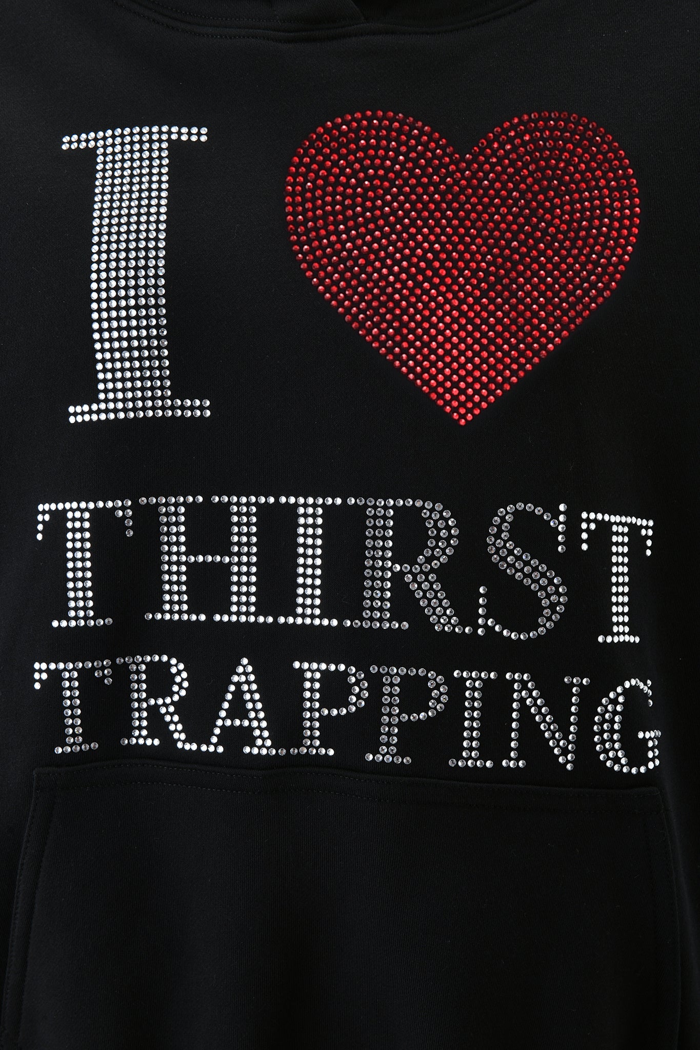 The POLINA HOODIE - THIRST TRAPPER by I.AM.GIA is a black hoodie with "I ♥ THIRST TRAPPING" in silver rhinestones and a red diamanté heart for a bold, glamorous look.