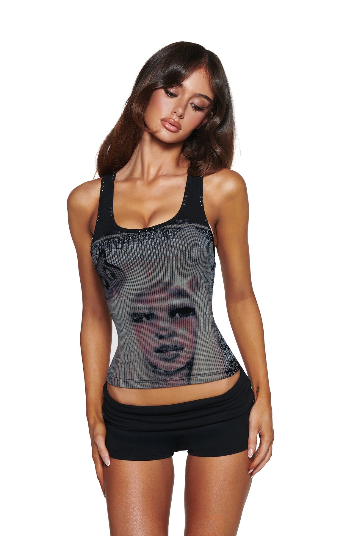 A woman with long brown hair poses in the I.AM.GIA T-REX INA TANK - BLACK, which features a bold face graphic, paired with black shorts against a plain white background.