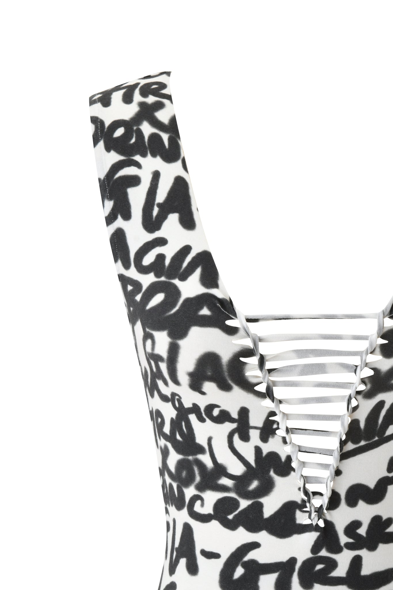 Close-up of the HONEY MACRAME TOP - WRITING ON THE WALL by I.AM.GIA, a sleeveless white top with black graffiti-style writing, deep V-neckline, and horizontal white straps across the front.