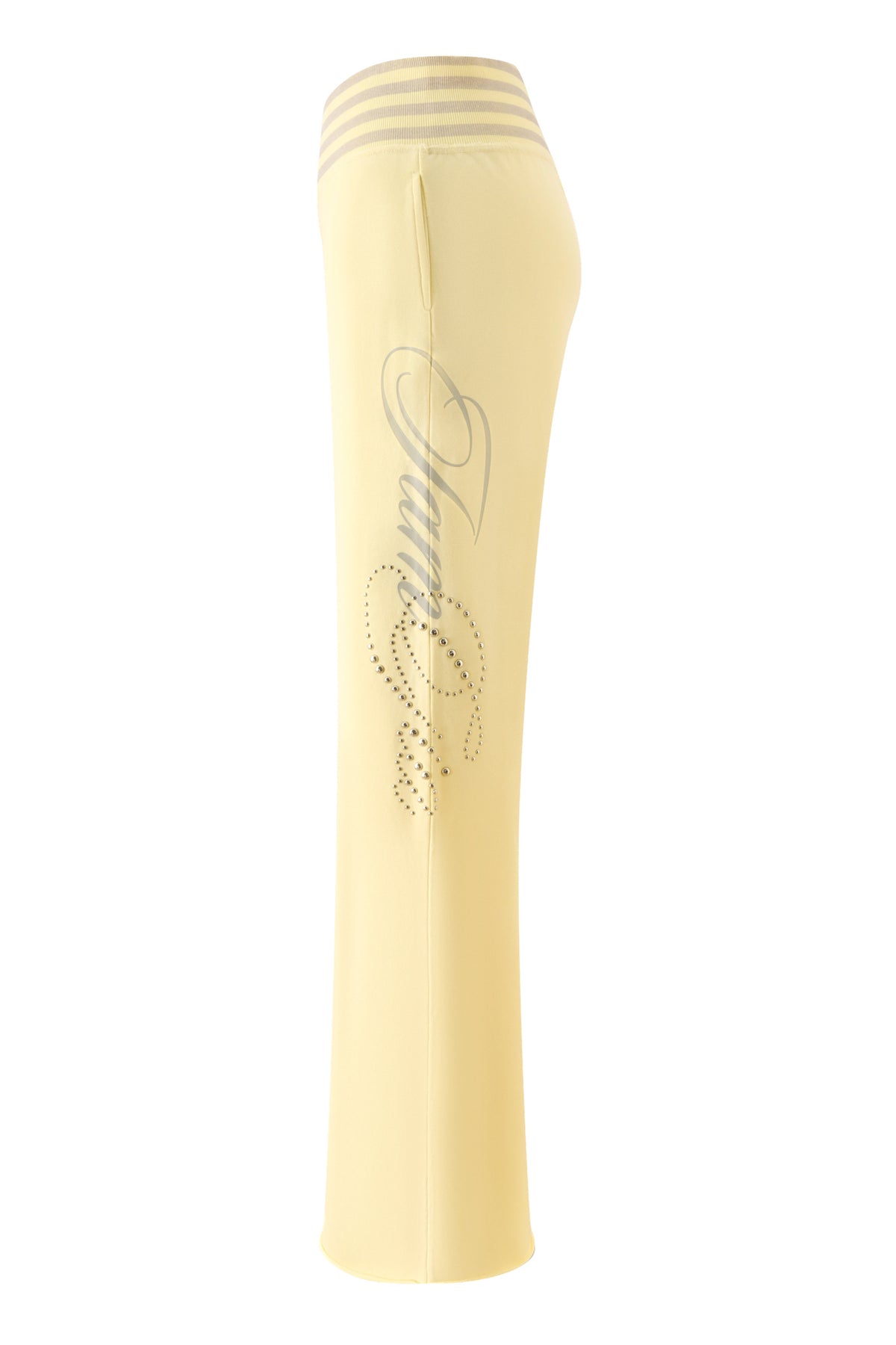 The VEDA PANT - YELLOW by I.AM.GIA features wide-leg yellow pants with a striped elastic waistband, decorative script, and rhinestone detailing along the side of the leg, shown against a white background.