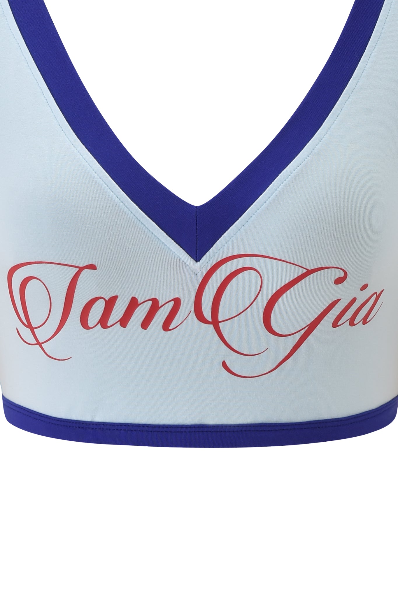 A close-up of the BLARE SPORT CROP TEE AND HEADBAND - BABY BLUE by I.AM.GIA, featuring a baby blue crop top with dark blue trim and "I.AM.GIA" in red cursive on the front.