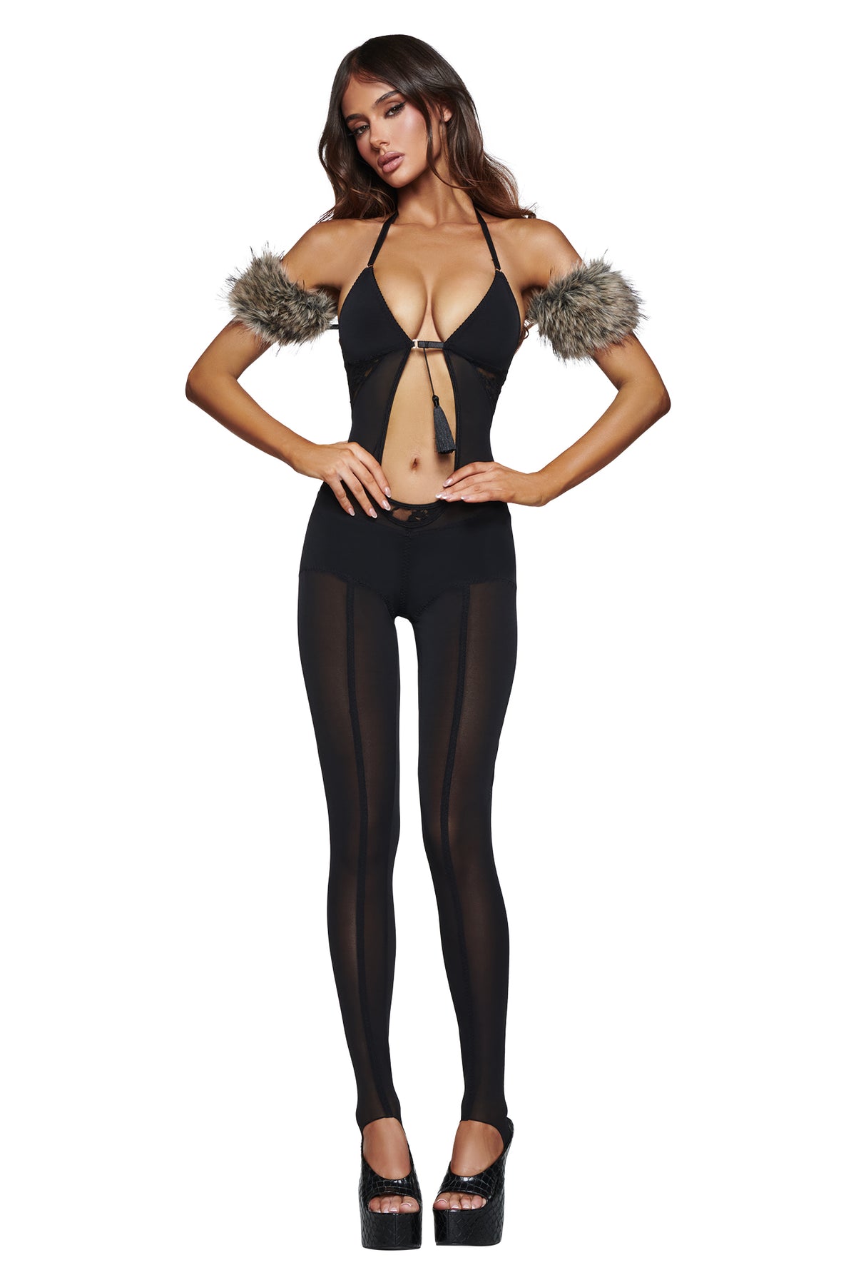 Model showcases the AZARI CATSUIT - BLACK by I.AM.GIA, featuring sheer mesh leggings, faux fur armbands, and paired with black high-heeled platform shoes against a white background—an eye-catching choice for a bold Halloween costume.