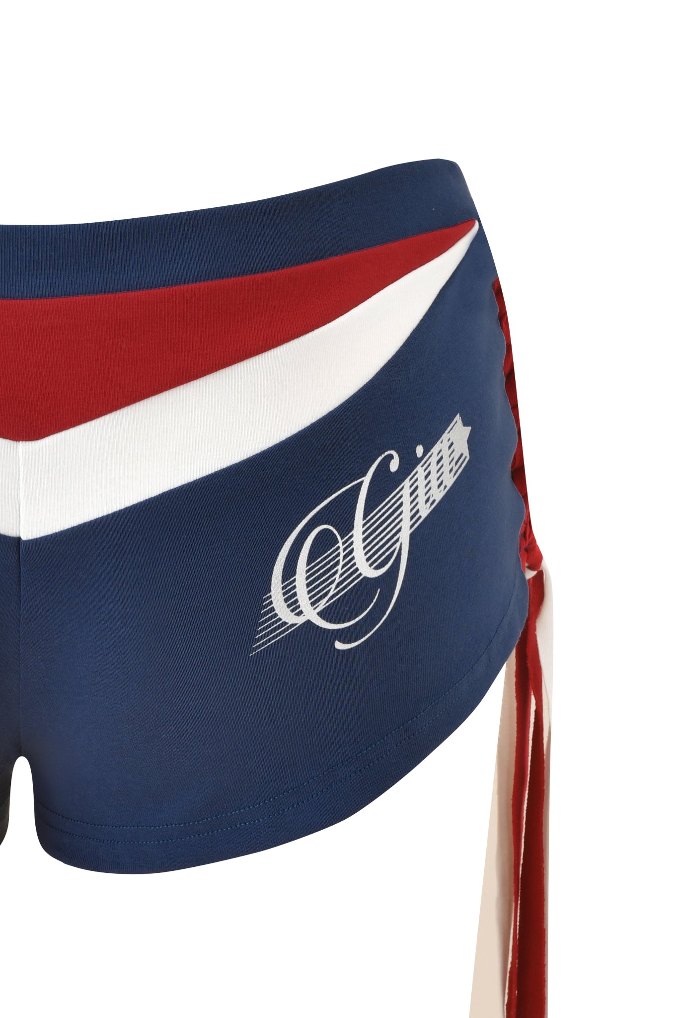 Close-up of the I.AM.GIA NOVIA MICRO SPORT SHORT - NAVY, featuring blue low-rise design with red and white stripes, lace-up red sides, and "Gills" in white cursive on the side.