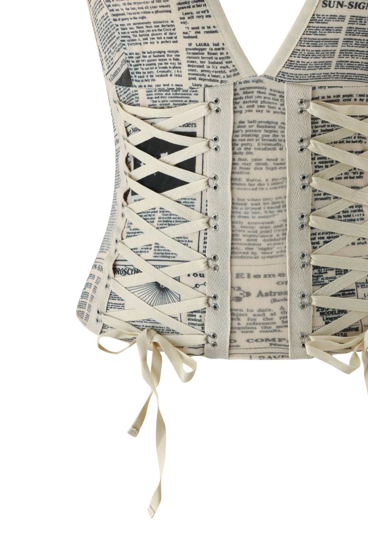 A close-up of the I.AM.GIA SORA TOP - LEFT ON READ, a bodycon corset top featuring cream laces and black and white newspaper text print.