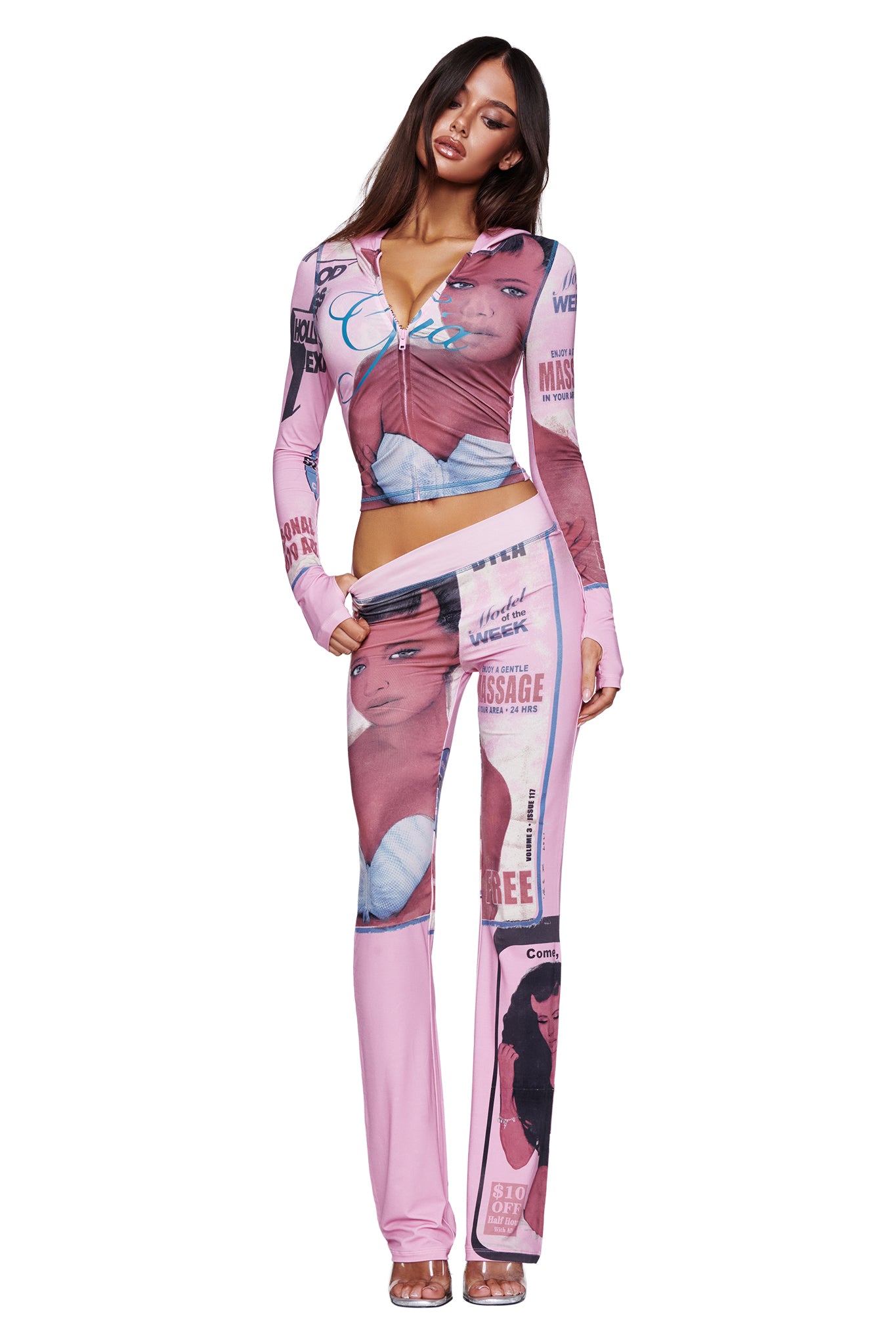A woman stands against a white background wearing the I.AM.GIA T-REX BLARE HOODIE in pink, featuring various magazine-style graphics and portraits of a woman's face.