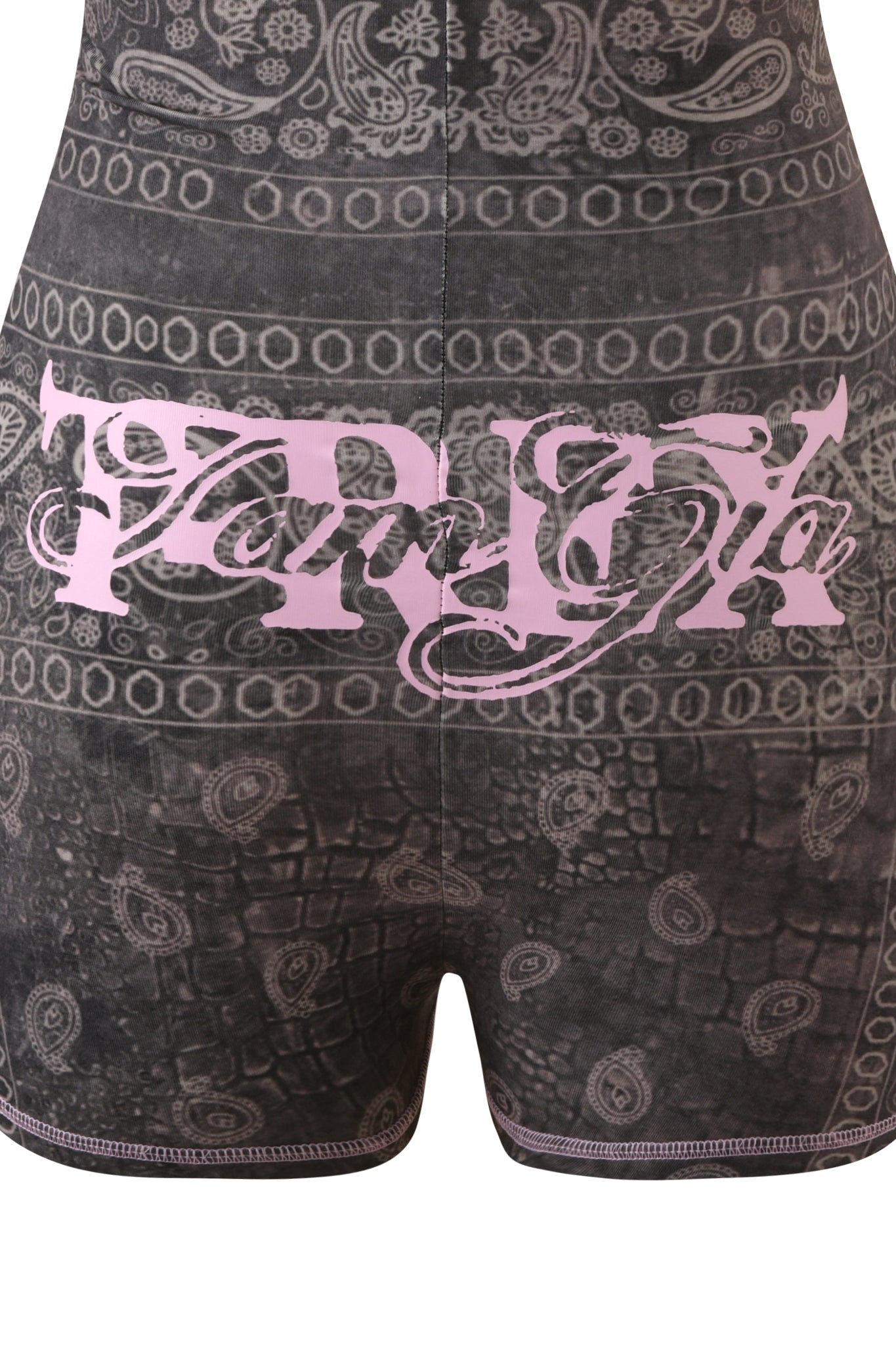 A close-up of the I.AM.GIA T-REX BLARE SHORT SLEEVE ROMPER in Charcoal Bandana, showcasing its black and gray bandana print with intricate paisley and geometric patterns, plus light pink decorative script text across the back—a statement festival outfit.