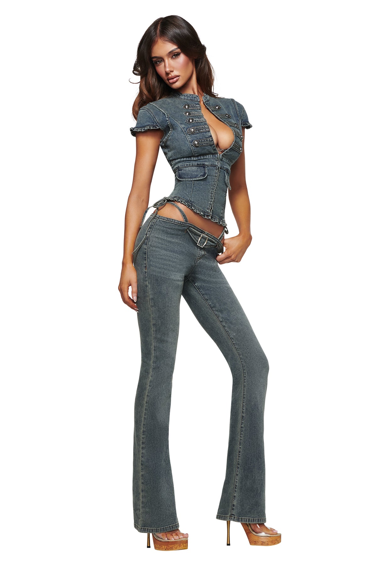 A woman poses confidently against a white background in I.AM.GIA’s JET G-STRING DENIM PANT in faded indigo, styled with high heels for an authentic Y2K outfits vibe.