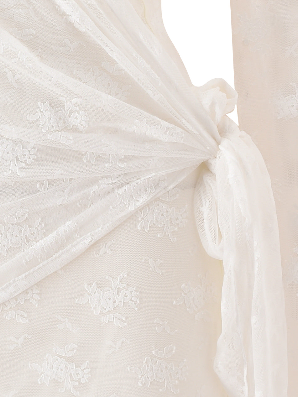 Close-up of the BONNY MINI DRESS in cream by I.AM.GIA, showcasing delicate white lace fabric with a floral pattern and a tied knot detail.