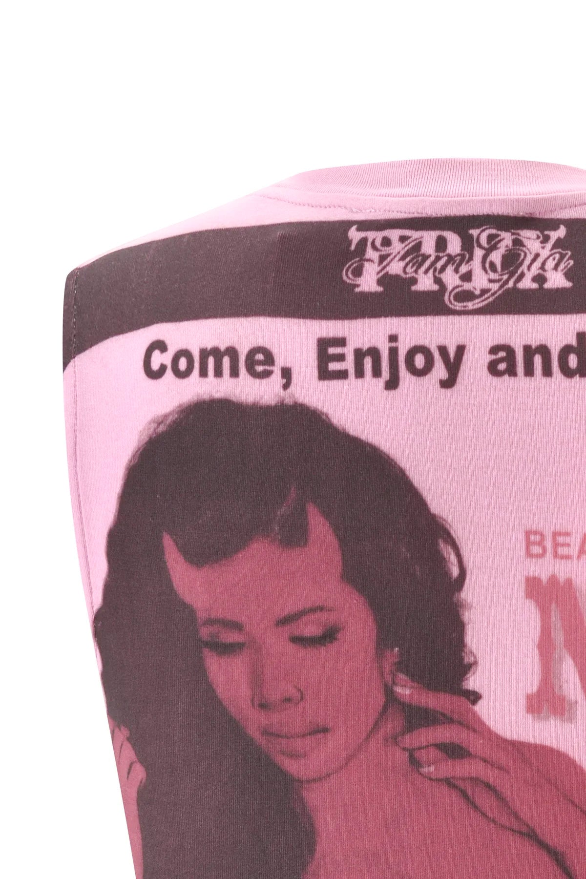 A close-up of the I.AM.GIA T-REX COURTNEY TANK in pink—a baby pink muscle tank made from heavyweight cotton jersey, featuring a vintage-style image of a woman with the text “Come, Enjoy and” above her; only the upper part of this graphic print tank is shown.