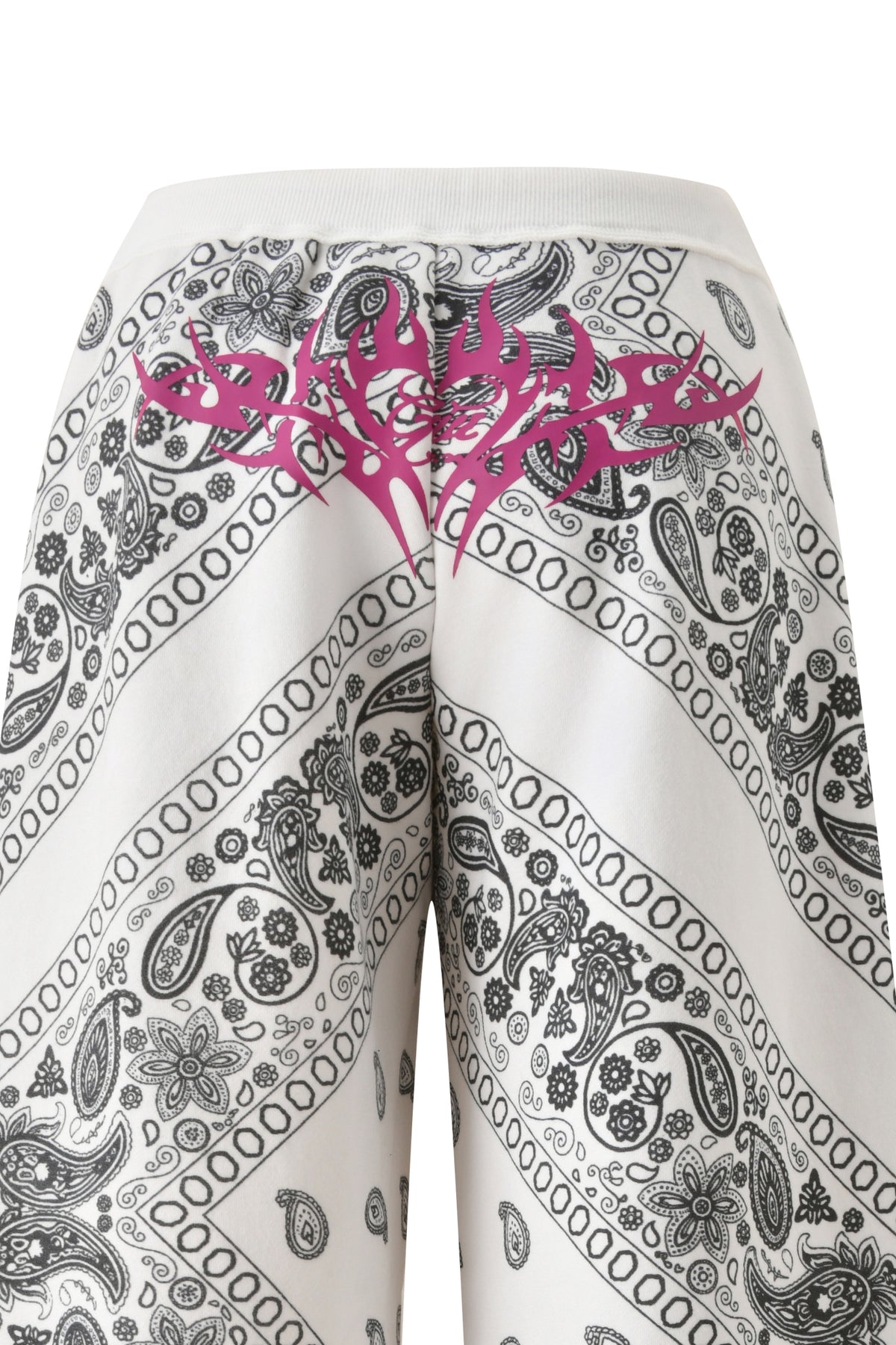 The T-REX TRACKPANT - PAISLEY by I.AM.GIA features white wide-leg sweatpants with black paisley bandana print and a bold pink tribal graphic near the waistband, from an exclusive collaboration.