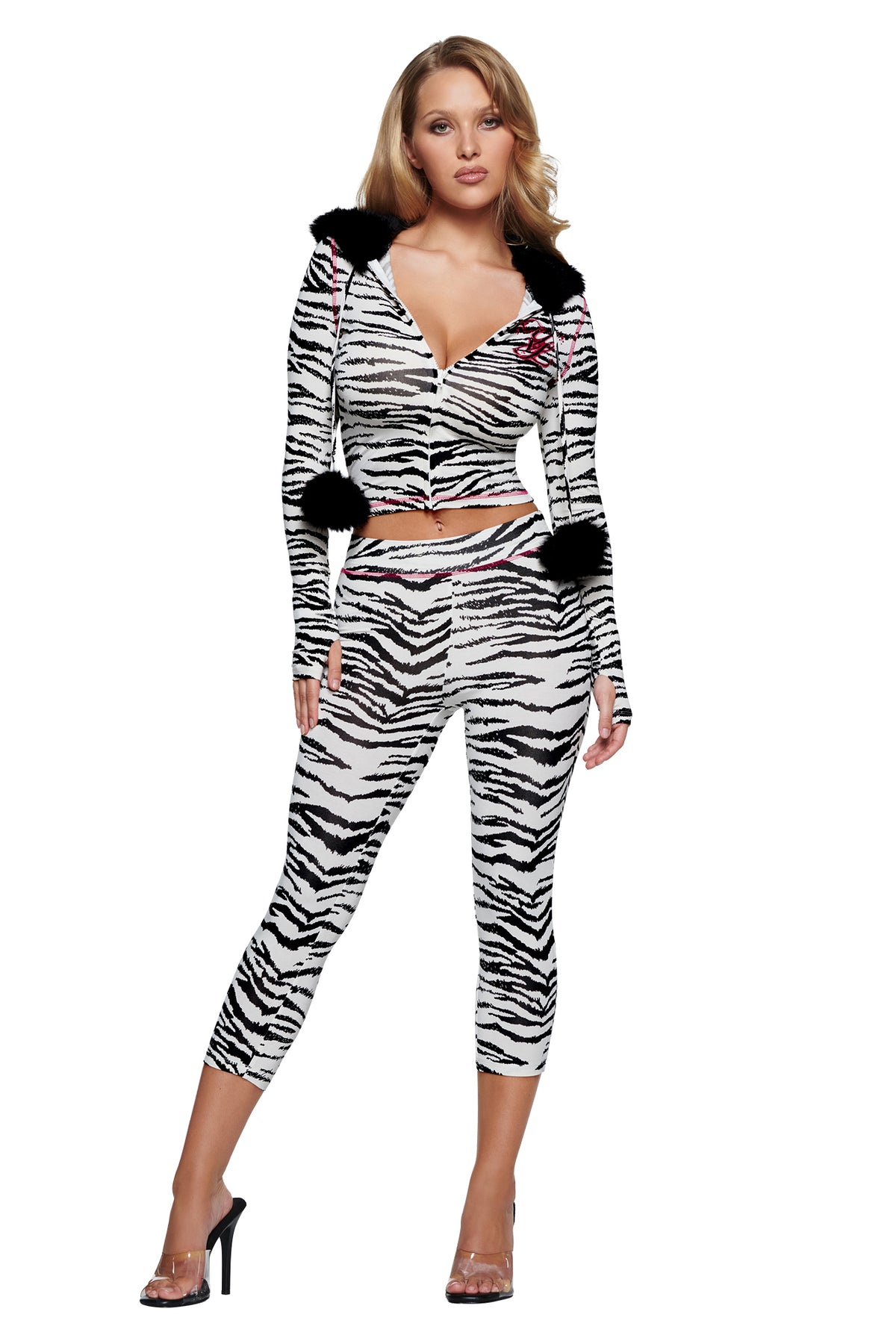 A woman wears a zebra-print zip-up hoodie with black pom-poms on the hood and matching YVL BLARE CAPRI - ZEBRA pants.