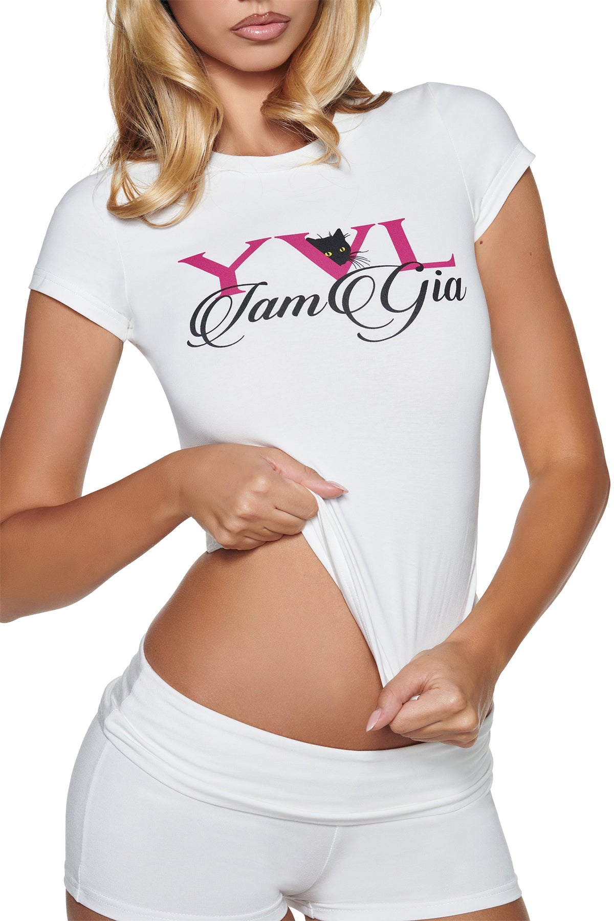 A person wears a white YVL T-SHIRT - WHITE CAT, featuring a pink “YVL” logo, a black cat, and black script text printed on the chest.