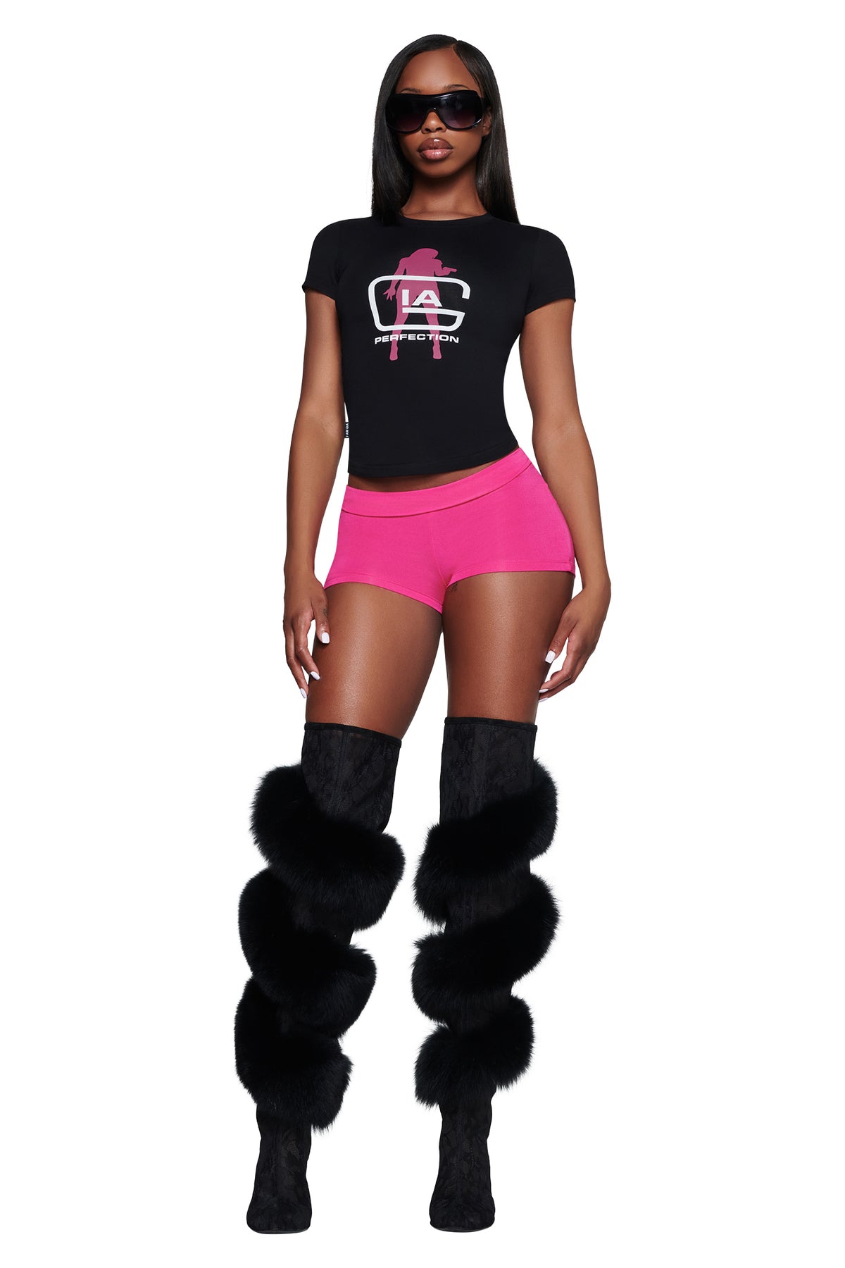 A person wears a black YVL T-SHIRT - BLACK GIA, pink booty shorts, and knee-high boots with black fur trim.