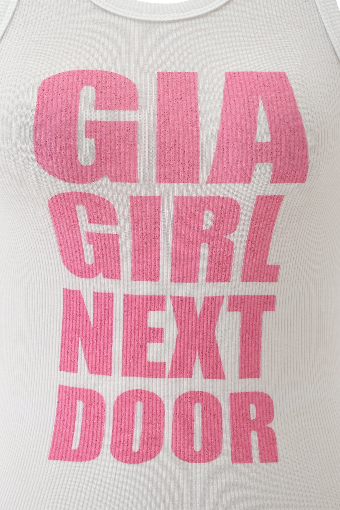 The PENELOPE TANK - GIRL NEXT DOOR by I.AM.GIA is a white rib knit tank with a bold hot pink glitter "GIA GIRL NEXT DOOR" graphic across the front.