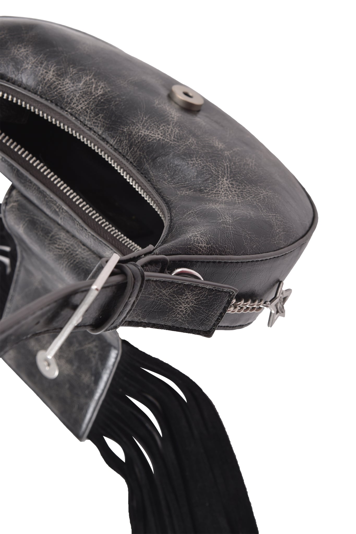 A close-up of the I.AM.GIA TIA BAG - BLACK FRINGE shows its textured black faux leather, zipper opening, metal button closure, fringe detail, and an adjustable strap partially visible.