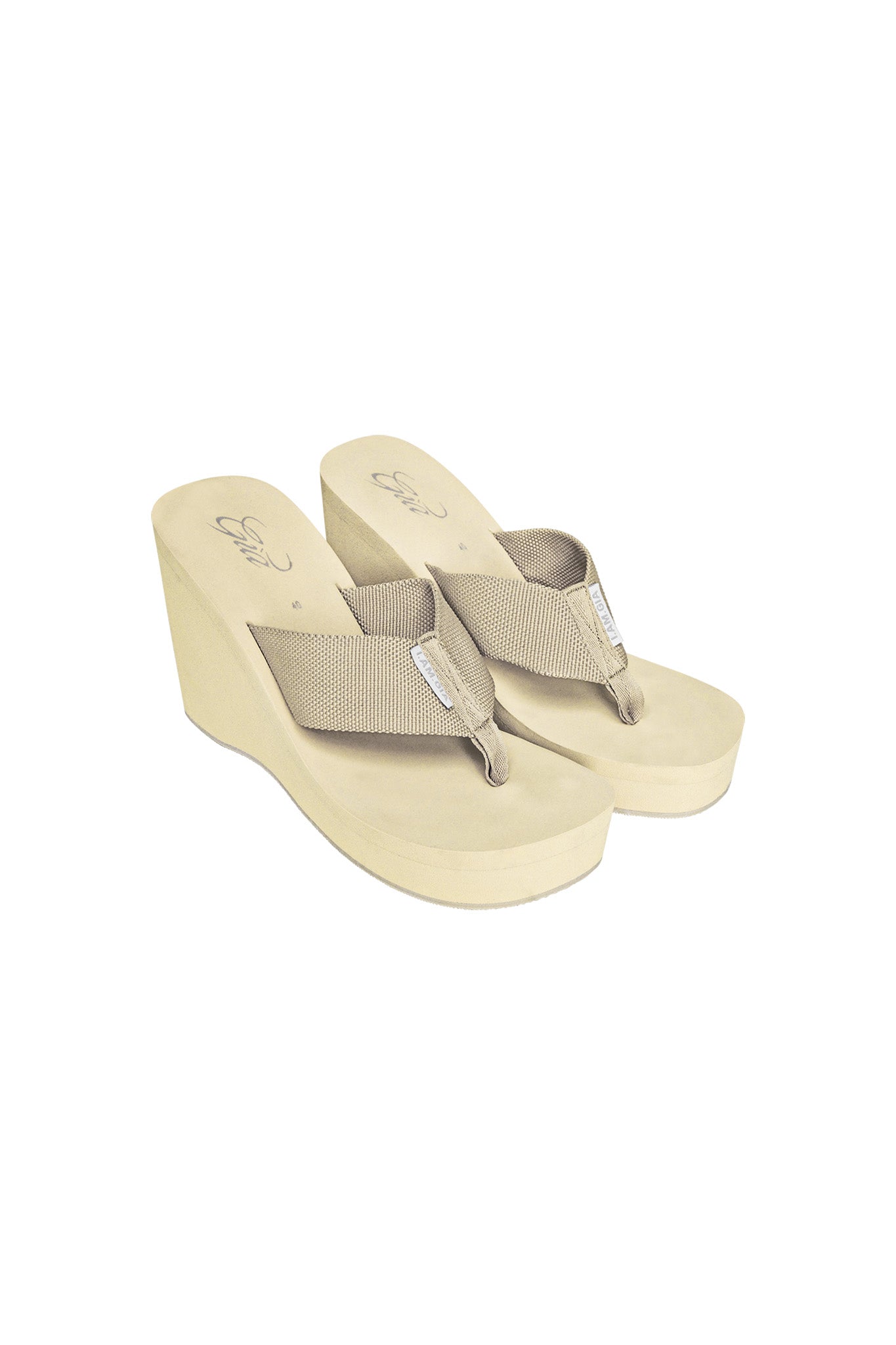 A pair of SHELBY FLIP FLOPS - NEUTRAL : TAN from I.AM.GIA featuring a fabric toe strap and wedge heel. These tan sandals have a slightly textured surface and an elevated heel for added height and comfort, photographed against a white background.