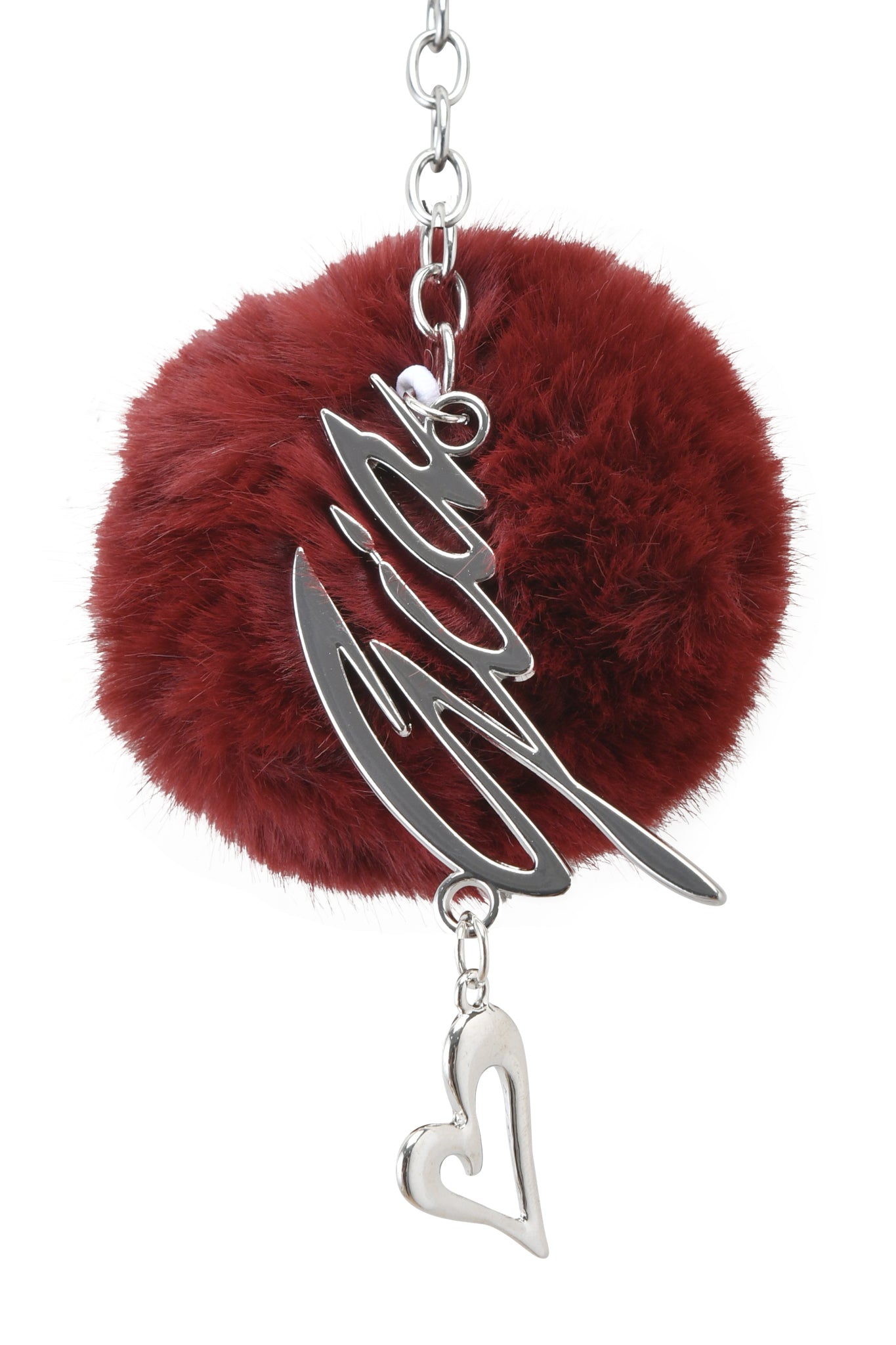 The I.AM.GIA LARSA KEYCHAIN - RED features a silver metal base, a deep red fluffy pom-pom, a script-shaped metallic charm, and a small dangling silver heart.