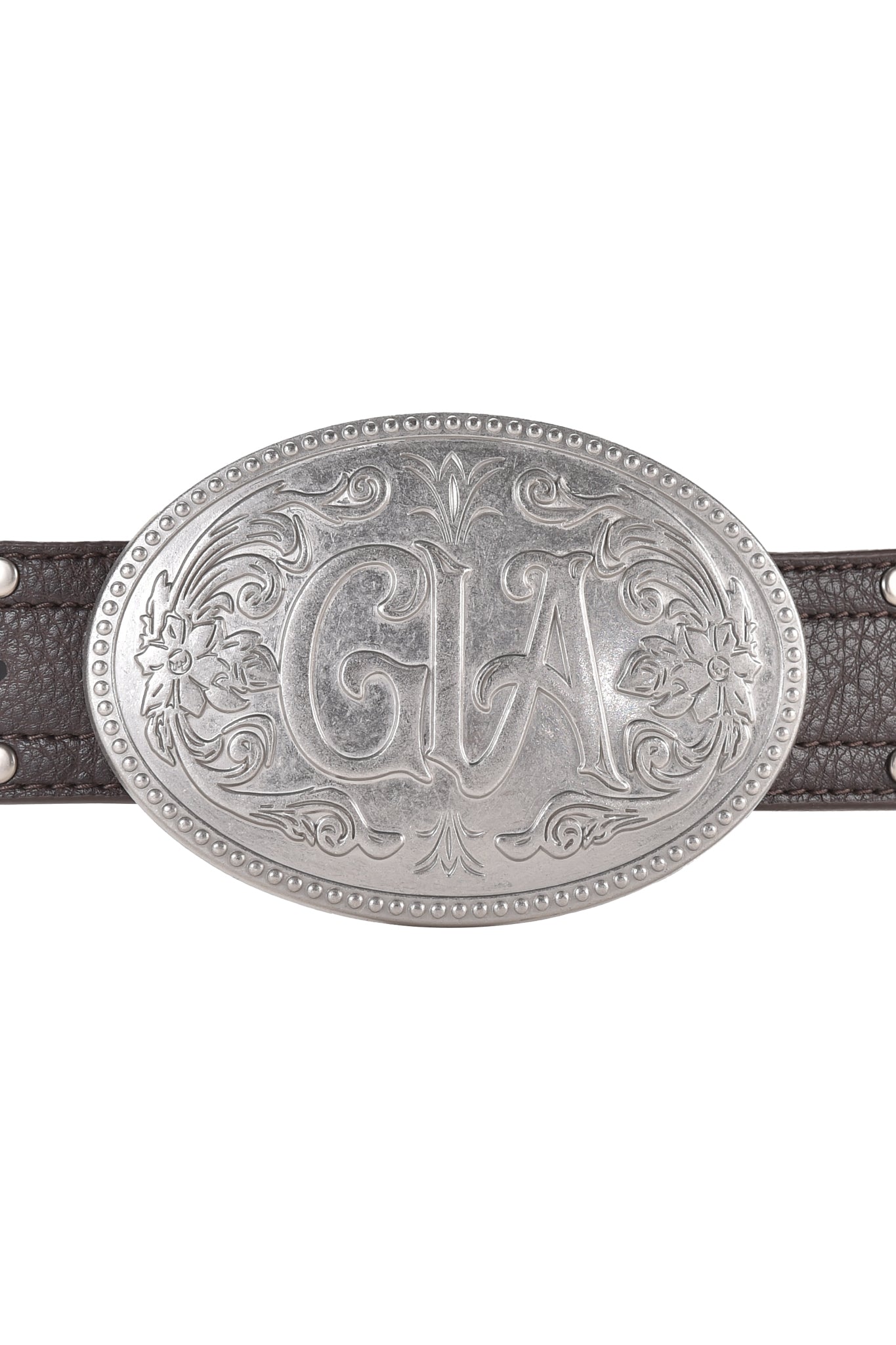 The COLTON BELT - BROWN by I.AM.GIA features a custom GIA buckle made of brushed silver with floral engravings and "GLA" initials, elegantly fastening to a dark faux leather belt.