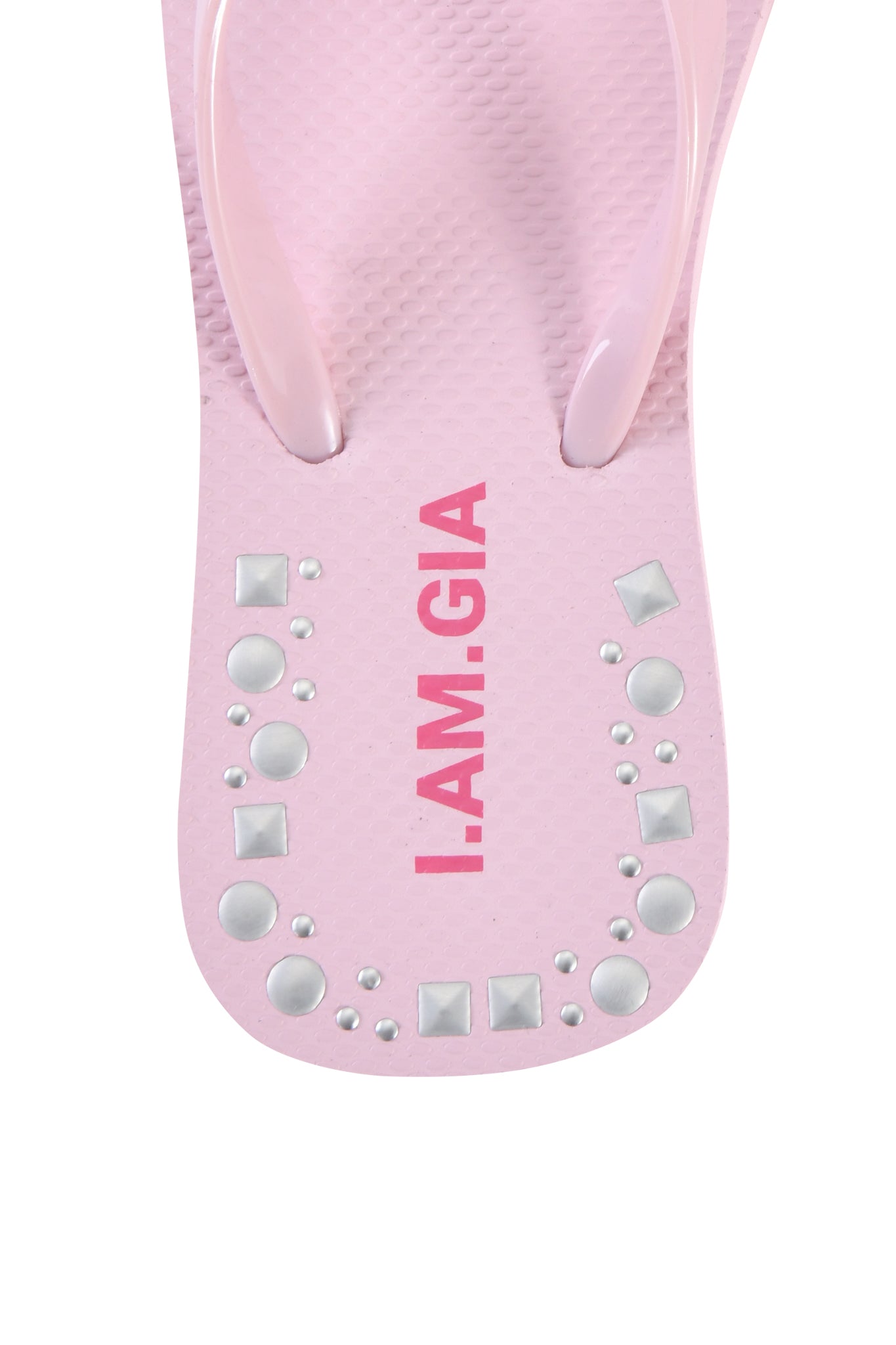 A close-up of the INKA STUDDED FLIP FLOP in baby pink by I.AM.GIA, featuring bold brand lettering and silver square and round studs along the edge of the square toe sandal.