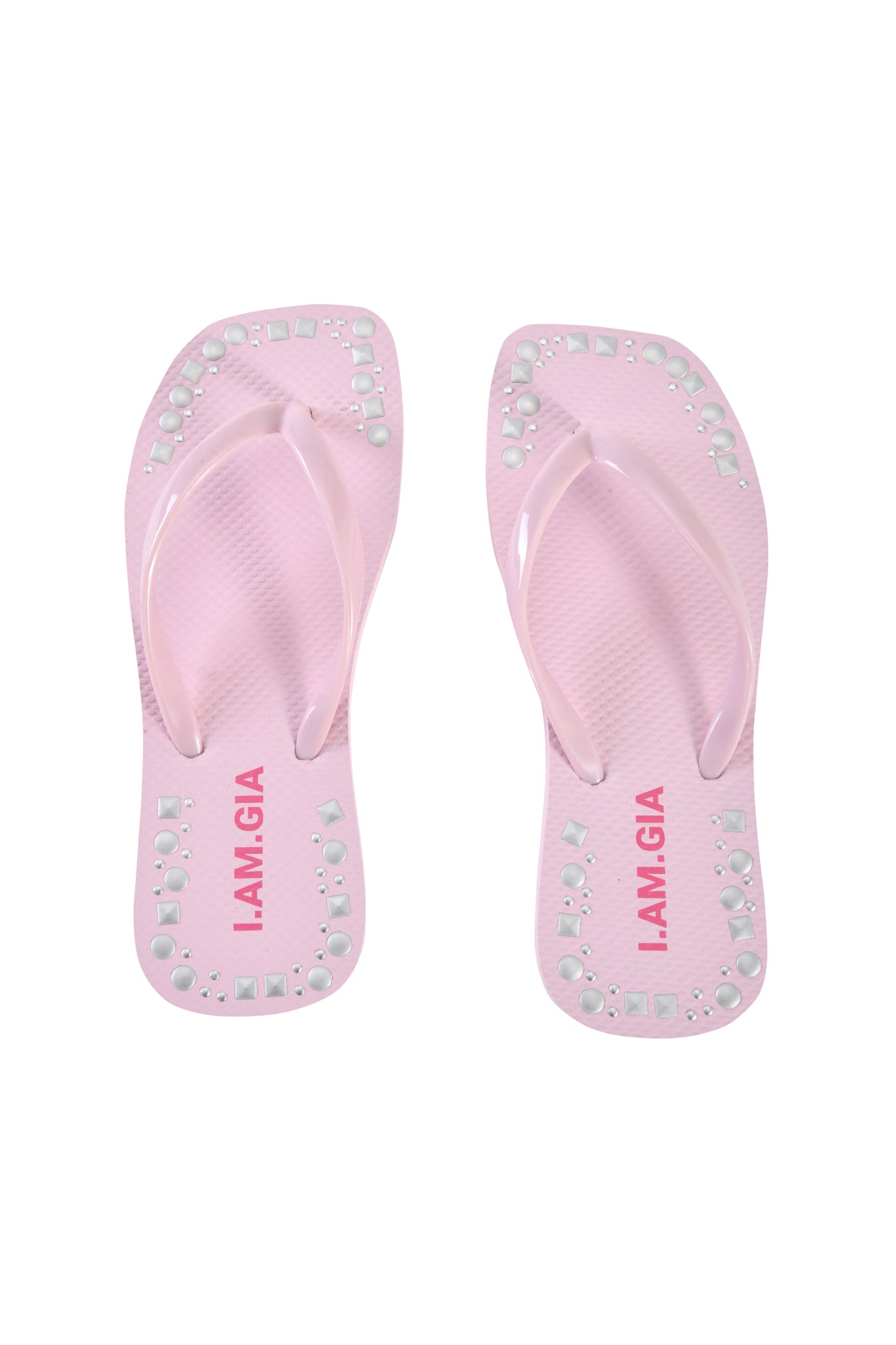 The INKA STUDDED FLIP FLOP in baby pink by I.AM.GIA features square and round studs along the edges and bold pink "I.AM.GIA" branding on the footbeds.