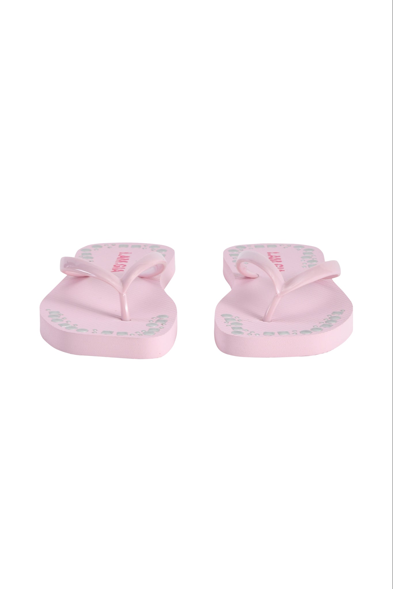 The INKA STUDDED FLIP FLOP in baby pink by I.AM.GIA features green and pink writing on the soles, shown front-facing against a white background.