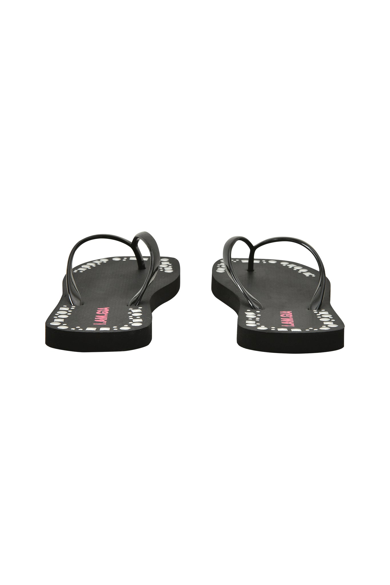 The I.AM.GIA INKA STUDDED FLIP FLOP in black, shown from the back with the soles facing forward, features white polka dot-edged straps and an extra-soft foam footbed on a plain white background.