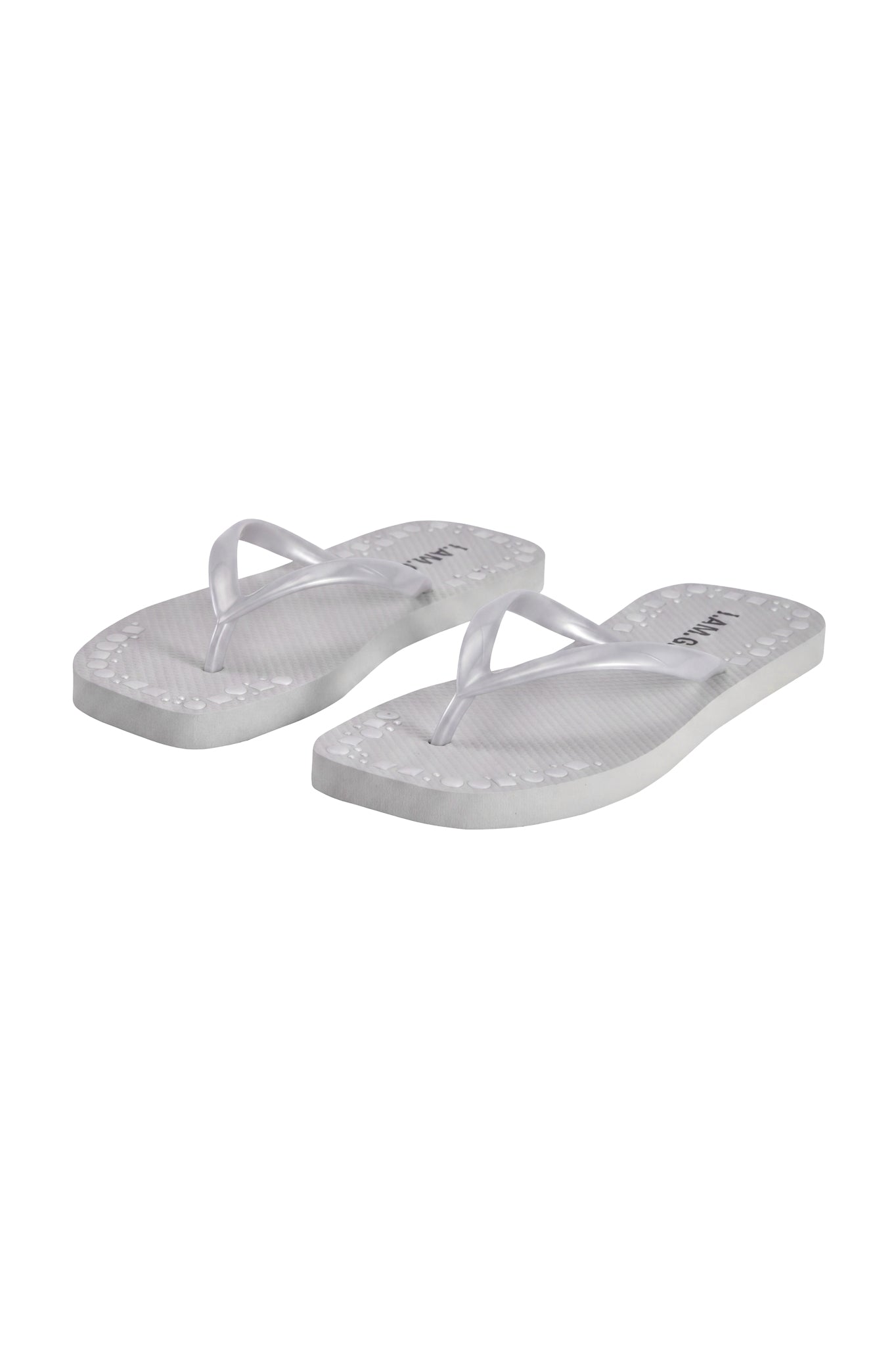 The INKA STUDDED FLIP FLOP - SILVER by I.AM.GIA features a comfortable footbed, textured soles, and thin silver straps, shown diagonally on a plain white background.