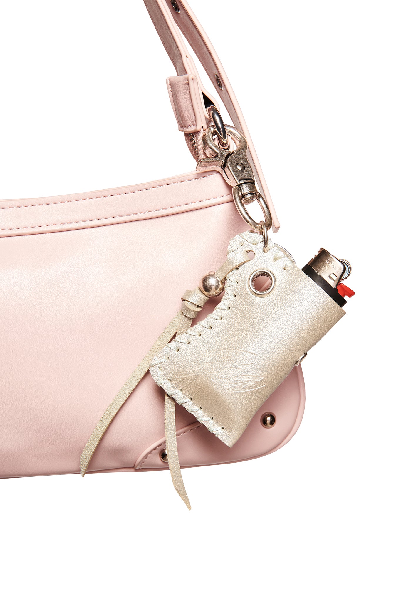 A close-up of a light pink handbag with an I.AM.GIA VENUS LIGHTER KEYCHAIN - SILVER, made from cream-colored leather and embossed with the GIA logo, attached to the strap and holding a black and red lighter.