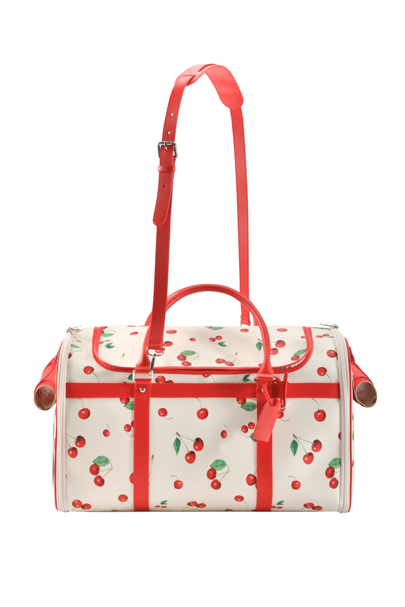 The I.AM.GIA TRIXX PET CARRIER - CHERRY ON TOP is a white, cylindrical duffel bag with red handles and straps, a vibrant cherry and green leaf print, metal accents on the ends, and functions as a stylish small pet carrier.