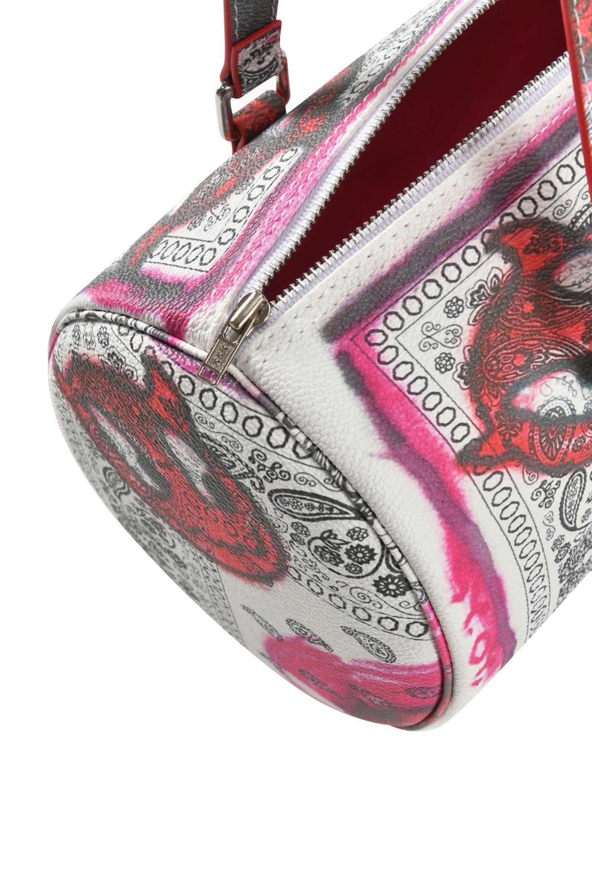 A close-up of the I.AM.GIA T-REX BARREL BAG - PAISLEY FACE, featuring a pink, red, and black paisley bandana print, silver zipper, matching strap, and bright pink interior.