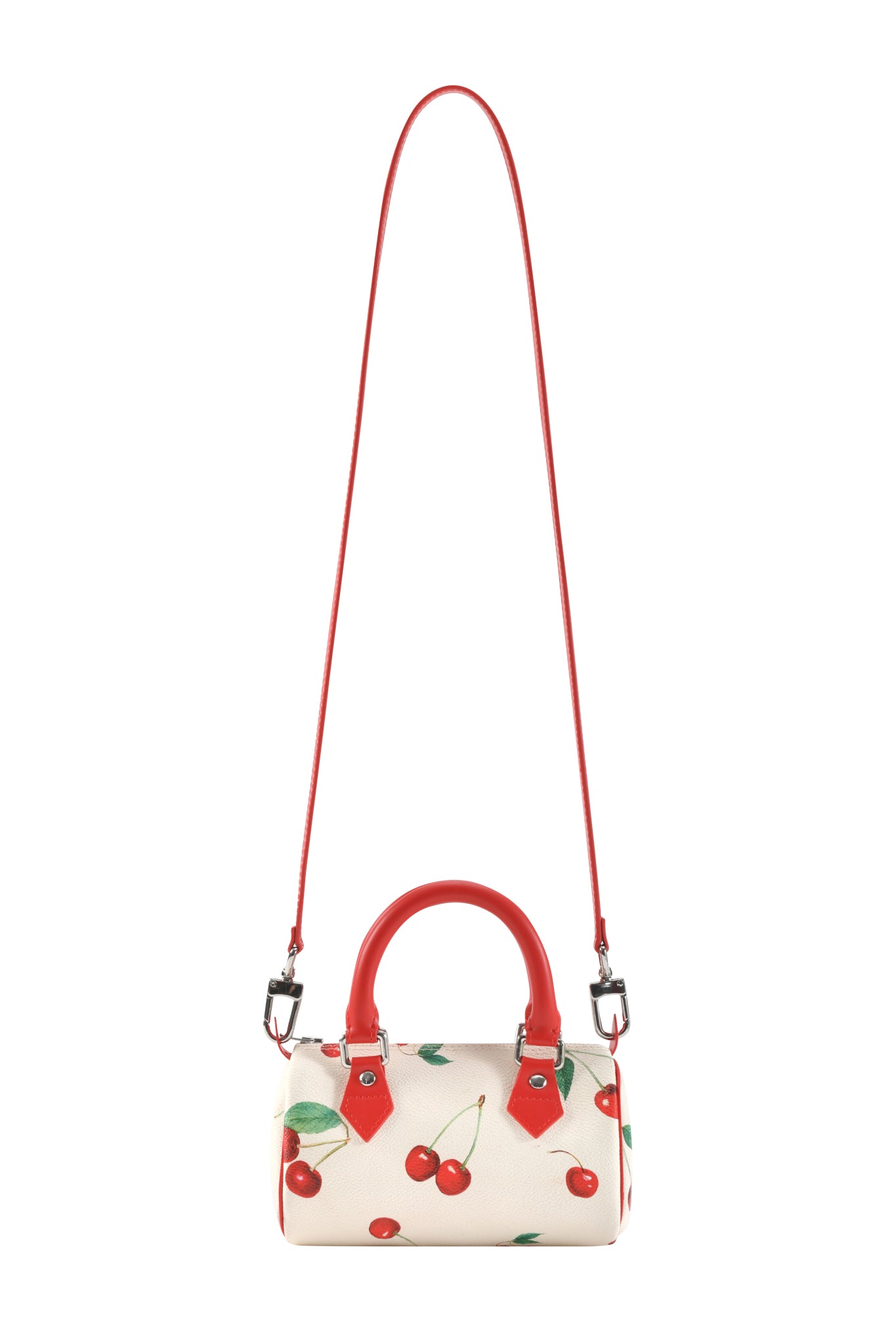 The I.AM.GIA NIKA MINI BAG - CHERRY ON TOP is a small white purse with red cherry and green leaf print, red handles, and a matching long shoulder strap.
