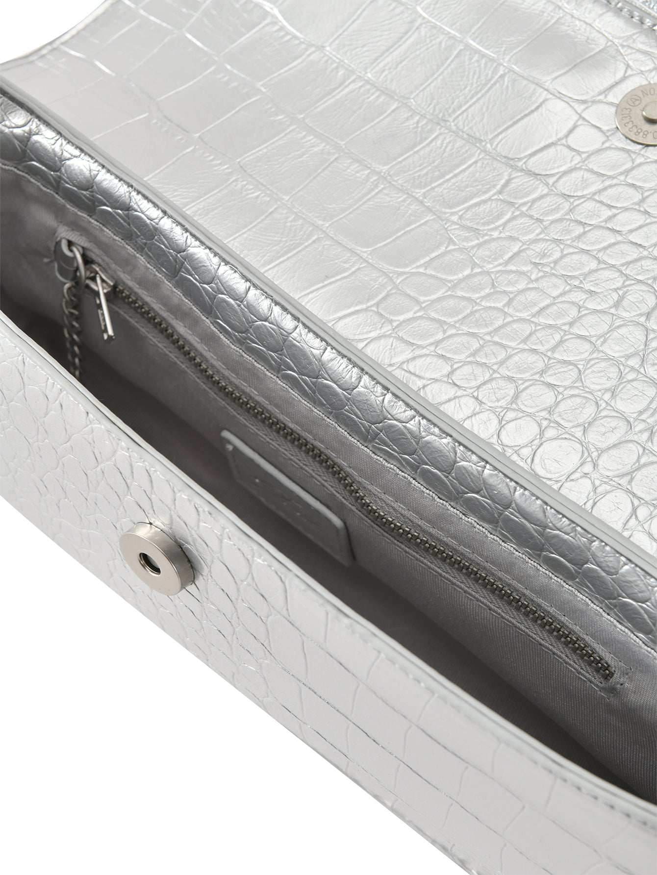 Close-up of the I.AM.GIA MILA METALLIC BAG in silver metallic, showing its faux crocodile texture, zippered pocket, magnetic snap closure, small chain key holder, and adjustable shoulder strap.