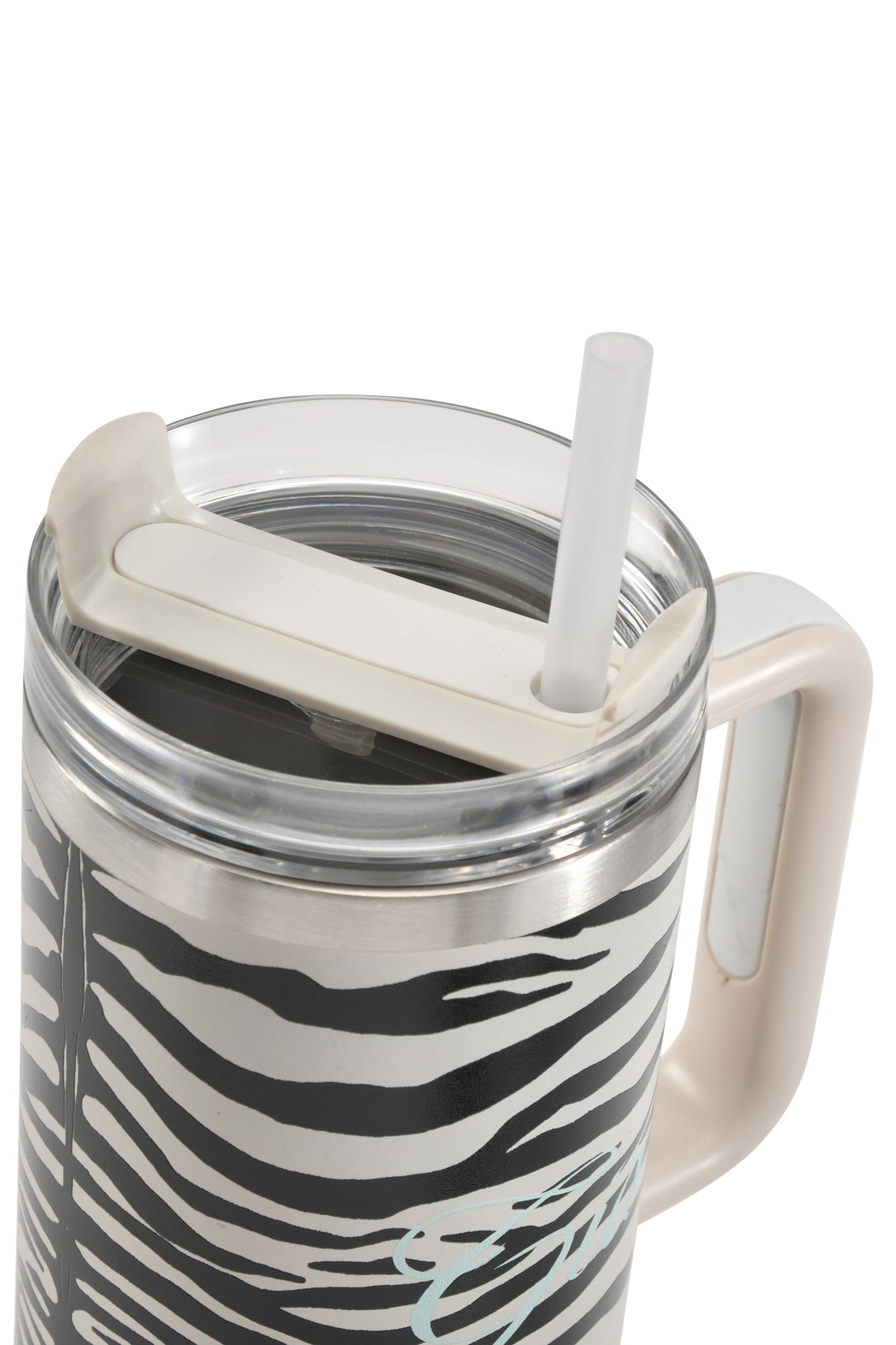 A close-up of the I.AM.GIA BLARE CUP - FINE LINE ZEBRA shows off its bold zebra stripe pattern, cream-colored lid, and clear straw inserted through the top. This insulated 40oz stainless steel tumbler features a large, light-colored handle for easy carrying.