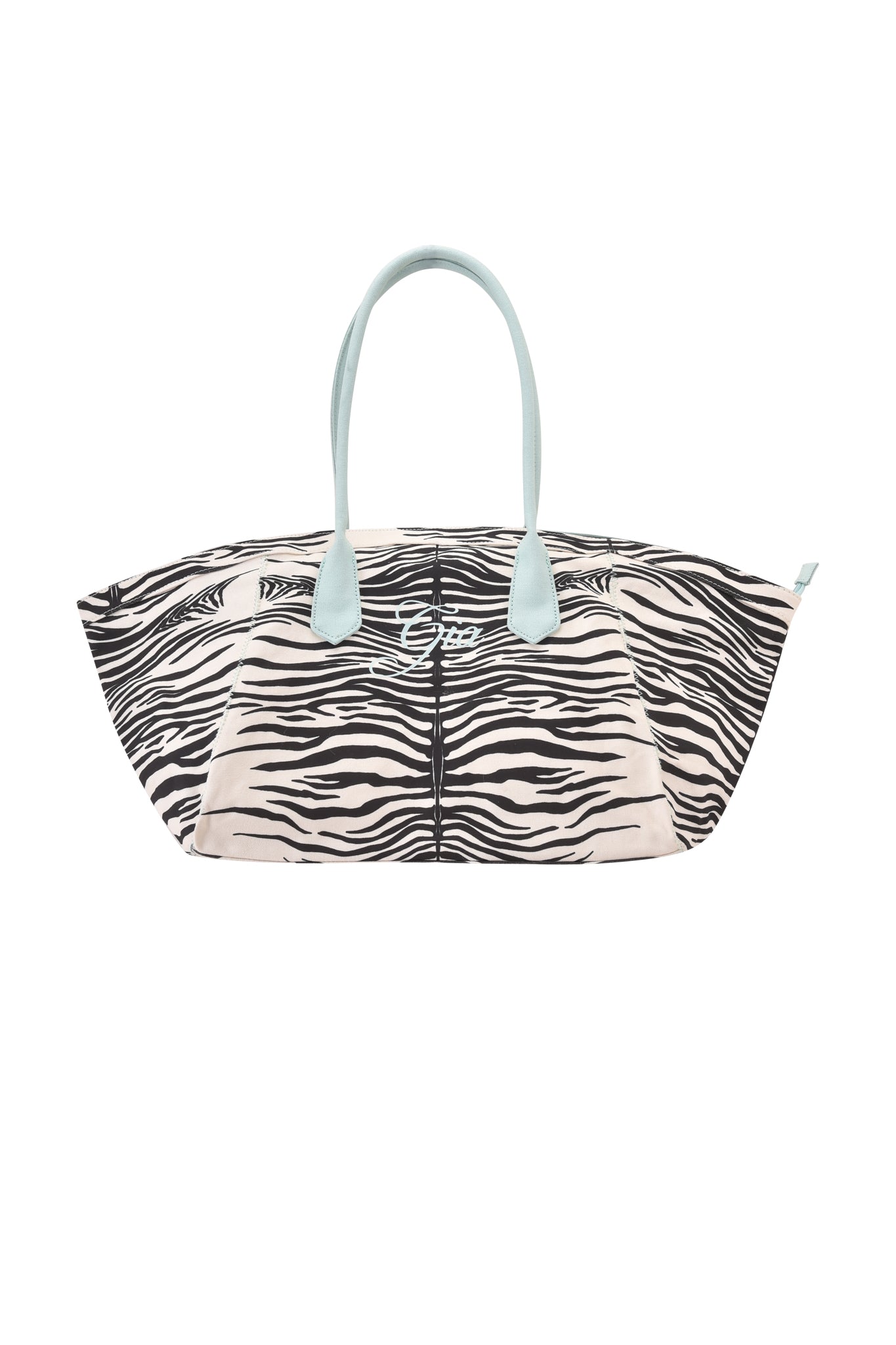The I.AM.GIA BLARE TOTE BAG - FINE LINE ZEBRA is an oversized tote featuring a bold zebra-print design, light blue handles, and “Grace” elegantly embroidered in white on the front. This standout shopper is photographed against a clean white background.