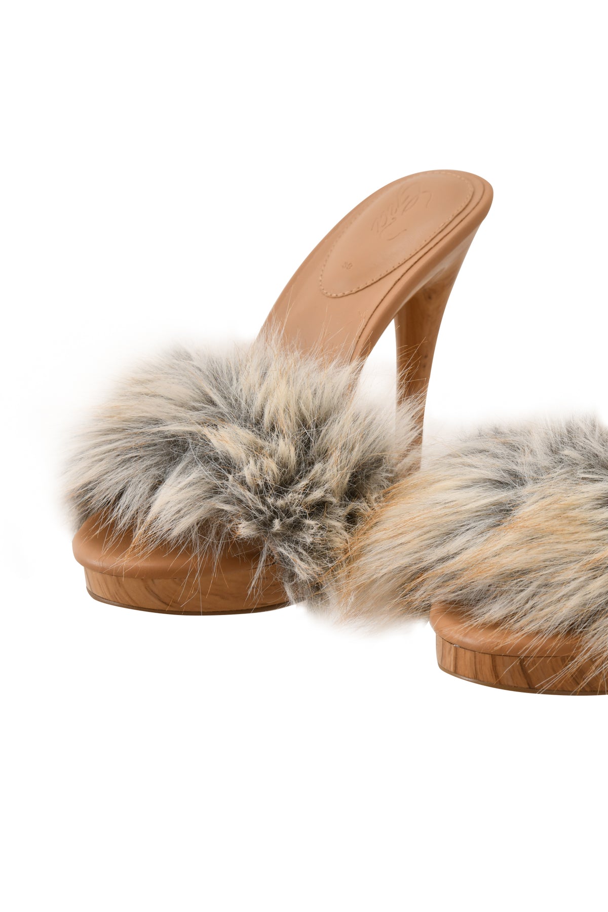 The NICKY HEEL - FAUX FUR TAN by I.AM.GIA showcases a tan high-heeled mule design with a front strap adorned in plush faux fur featuring a blend of grey, white, and brown hues, displayed against a white background.