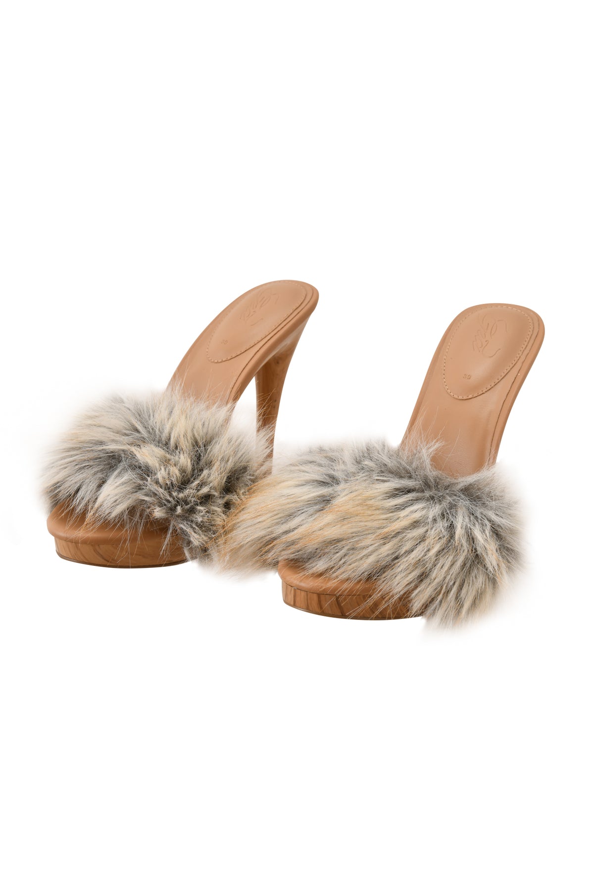 A pair of I.AM.GIA NICKY HEEL - FAUX FUR TAN sandals, featuring high heels, tan soles, and beige faux fur straps, displayed on a white background.