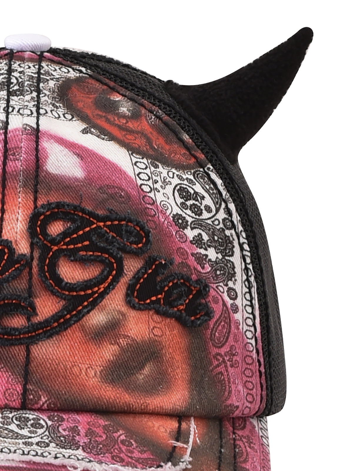 A close-up of the I.AM.GIA T-REX DEVIL HAT - BLACK, featuring printed designs, embroidered script, and black devil horns on top.