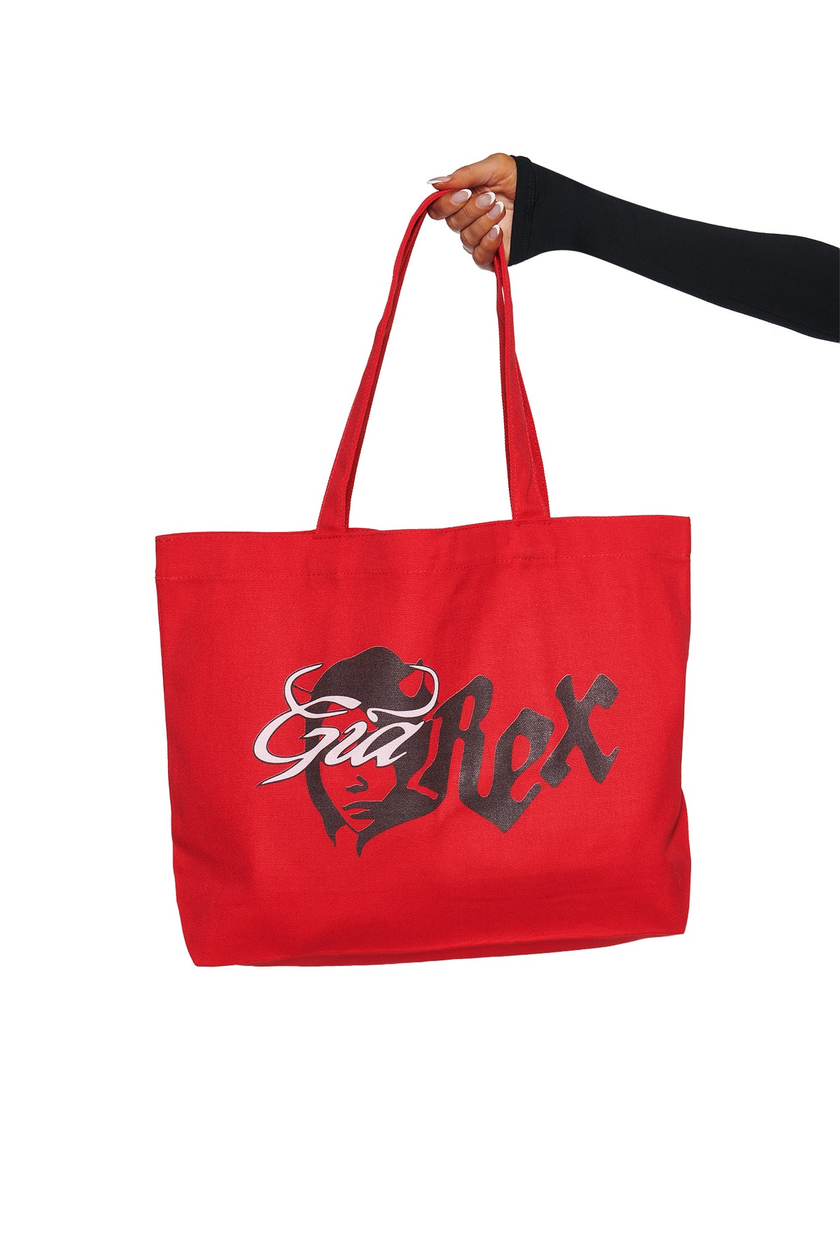 A hand holds the I.AM.GIA T-REX TOTE BAG - RED, featuring “Sad Rex” and a stylized face in black on the front, standing out against a white background.