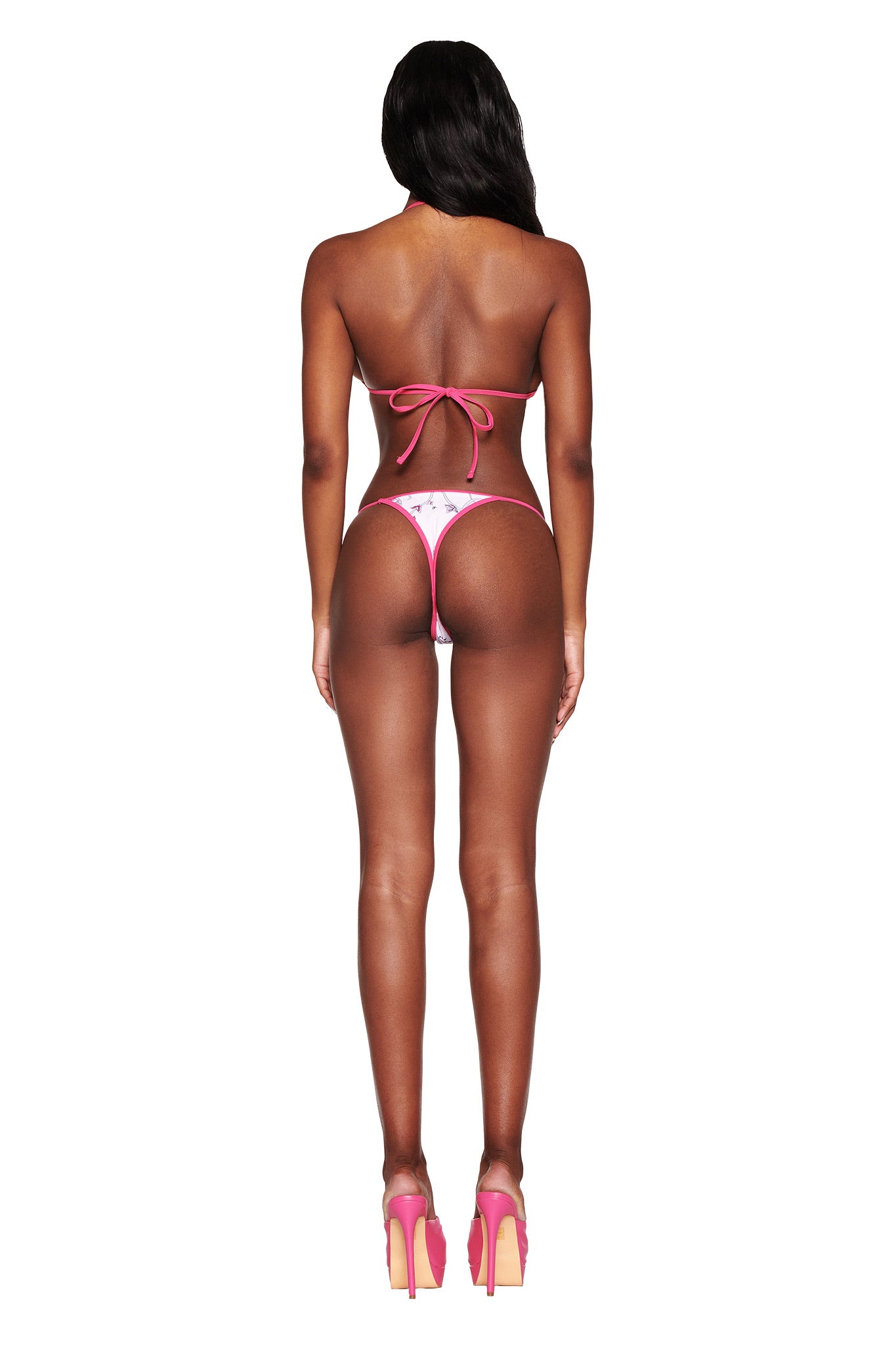 Rear view of someone wearing the pink CORDELIA 2.0 BIKINI TOP with butterfly ribbon from I.AM.GIA, paired with matching high heels, against a plain white backdrop.