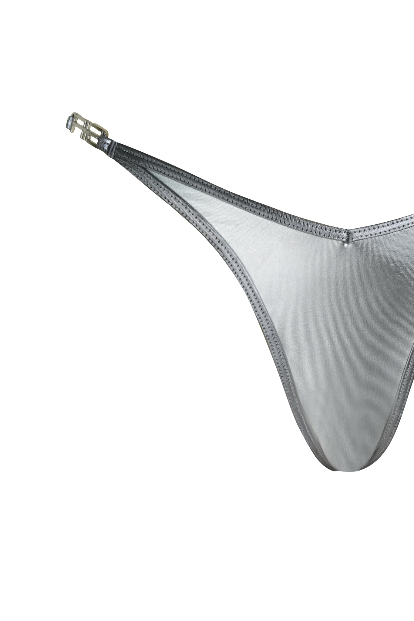 The LIOR BIKINI BOTTOM - SILVER by I.AM.GIA features a metallic silver finish, thin adjustable straps, and a small buckle on the left side, shown in close-up on a white background.