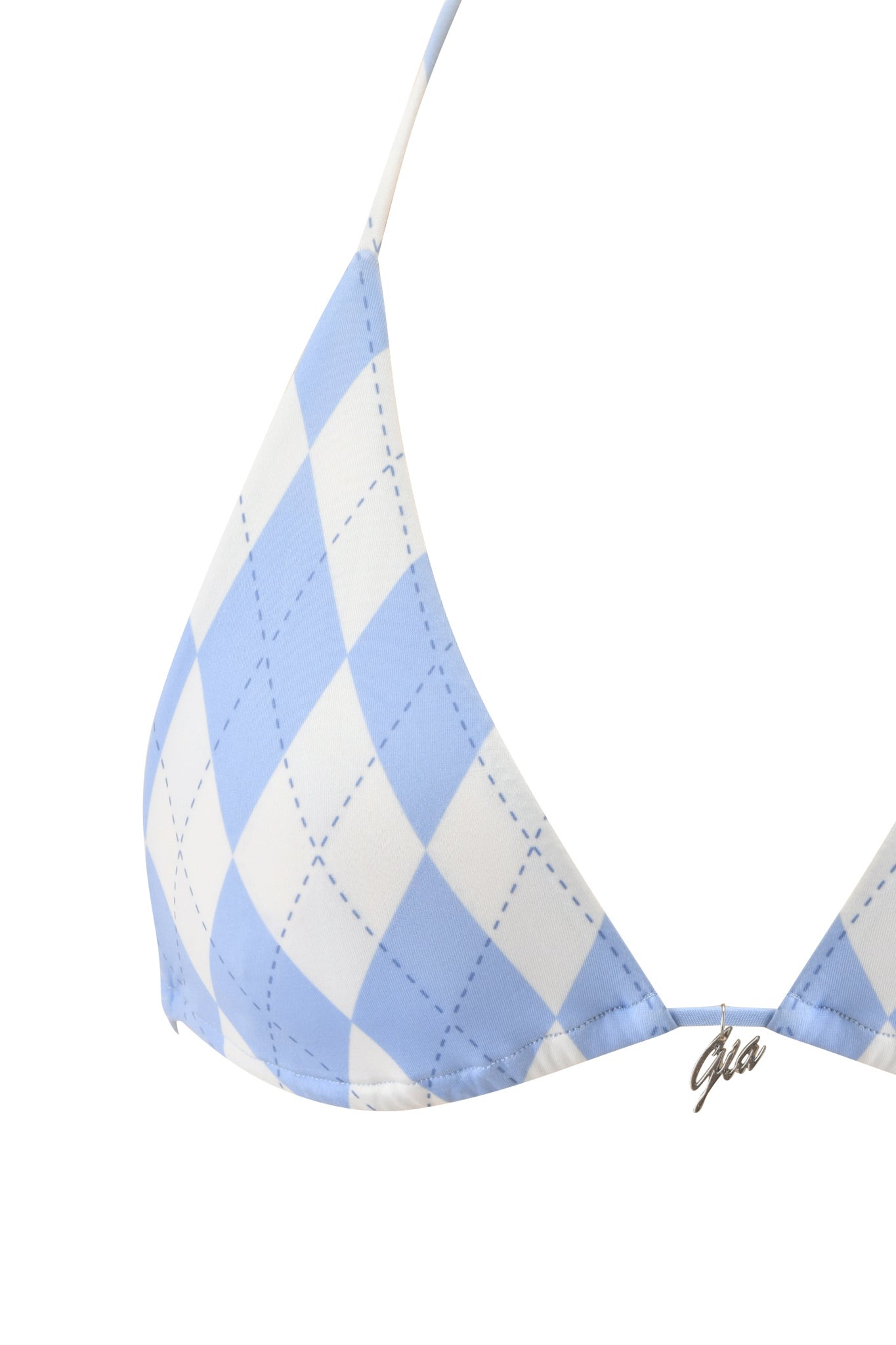 Close-up of the I.AM.GIA BRITT BIKINI TOP - BLUE ARGYLE, showing blue and white checks, stitched diagonal lines, a metallic "gia" charm at the center, and a blue argyle print accentuating the halter neck style.