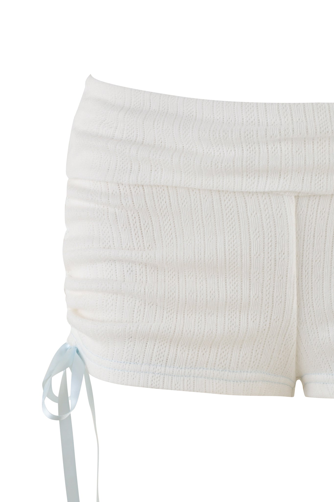 The MIA SHORT - WHITE by I.AM.GIA are white crochet-style, low-rise shorts featuring a ruched design and a light blue ribbon tie on one side.