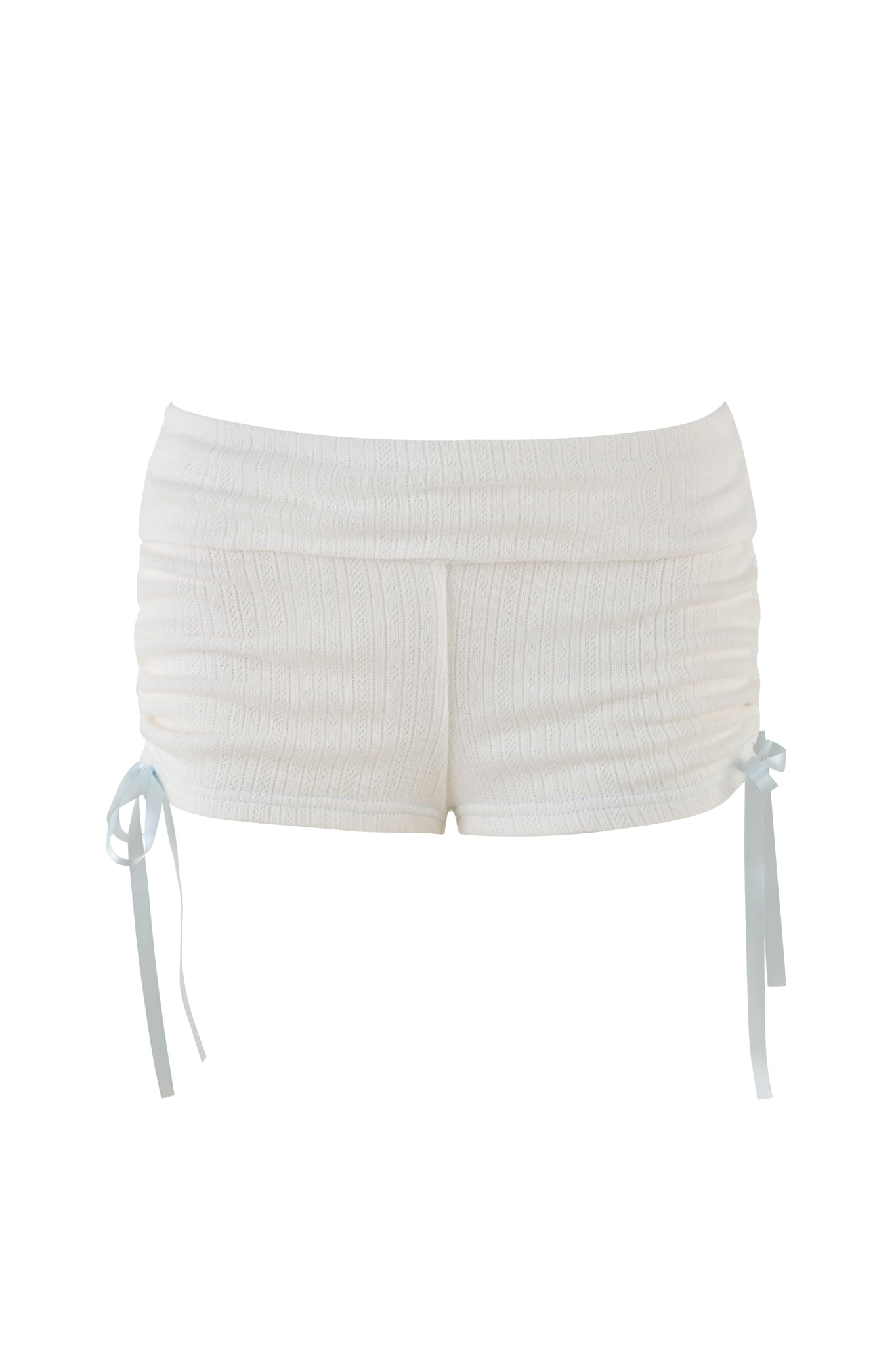 The MIA SHORT - WHITE by I.AM.GIA are low-rise, textured white mini-length bodycon shorts featuring a ribbed pattern. They have ruching on the sides accentuated with light blue ribbon ties and appear to be crafted from a soft, stretchy fabric.