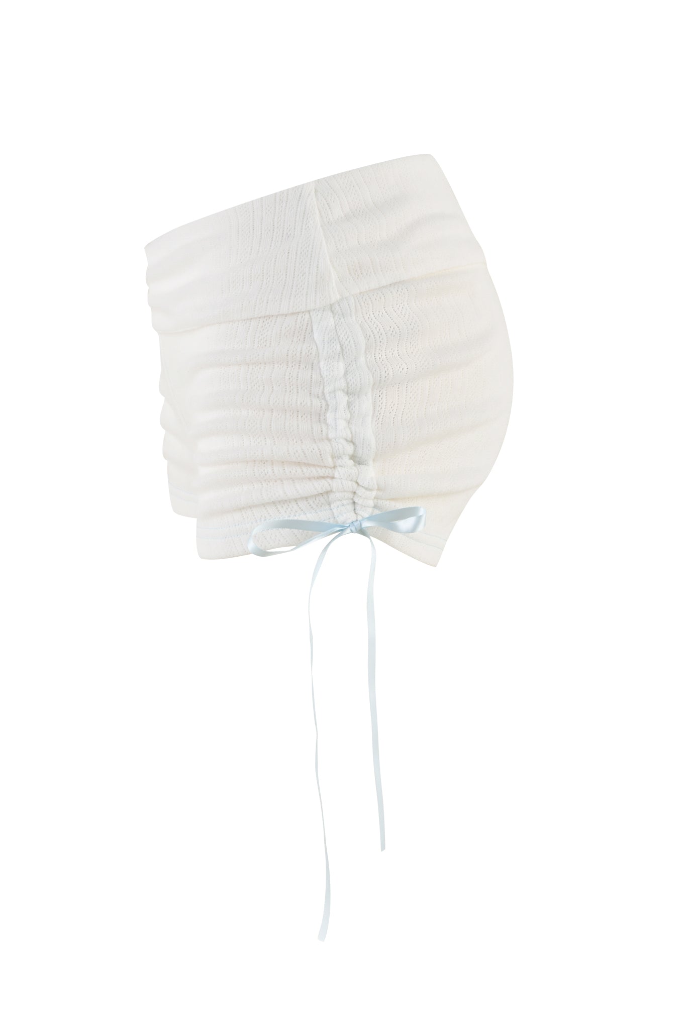 The I.AM.GIA MIA SHORT in white is an adult bonnet hat featuring a textured design with ruched detailing and a light blue ribbon tie at the bottom, as seen from the side. The bonnet has a soft, gathered appearance that evokes low-rise fashion trends, with the ribbon adding a delicate touch to its overall aesthetic.