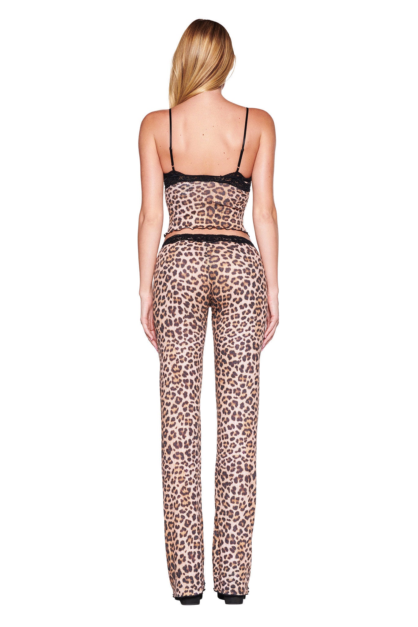 A woman with long blonde hair is shown from the back wearing the CASSIA TOP - NEUTRAL : LEOPARD by I.AM.GIA. The ensemble features a sleeveless, lace-trimmed top and matching high-waisted, wide-legged pants. She is standing against a plain white background.