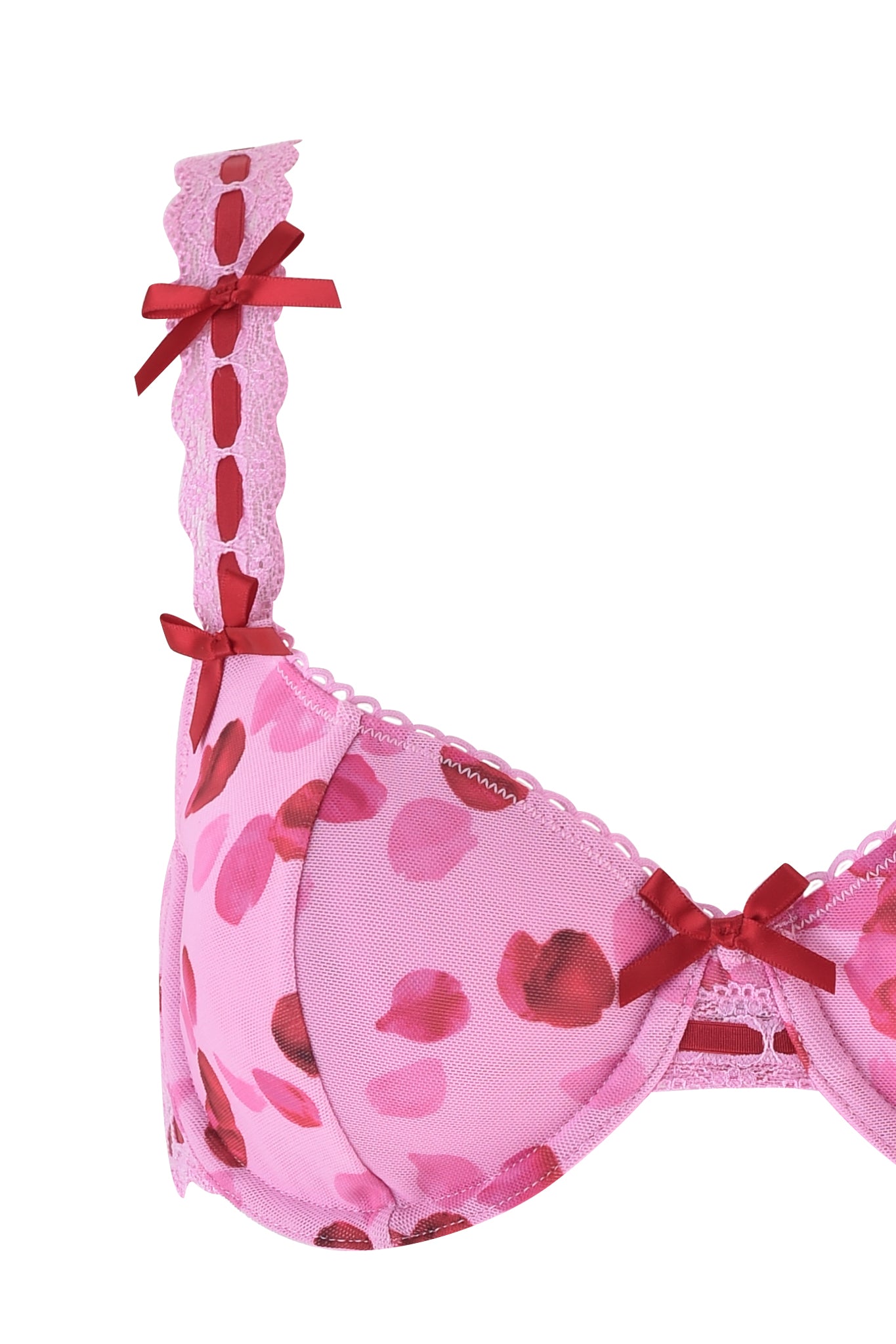 A close-up of the I.AM.GIA Gabriella 2 Piece Set - Pink: Pretty Petal shows a pink underwire bra with red leaf patterns and bows, featuring scalloped lace strap details, adjustable straps, and a delicate lace trim for added elegance.