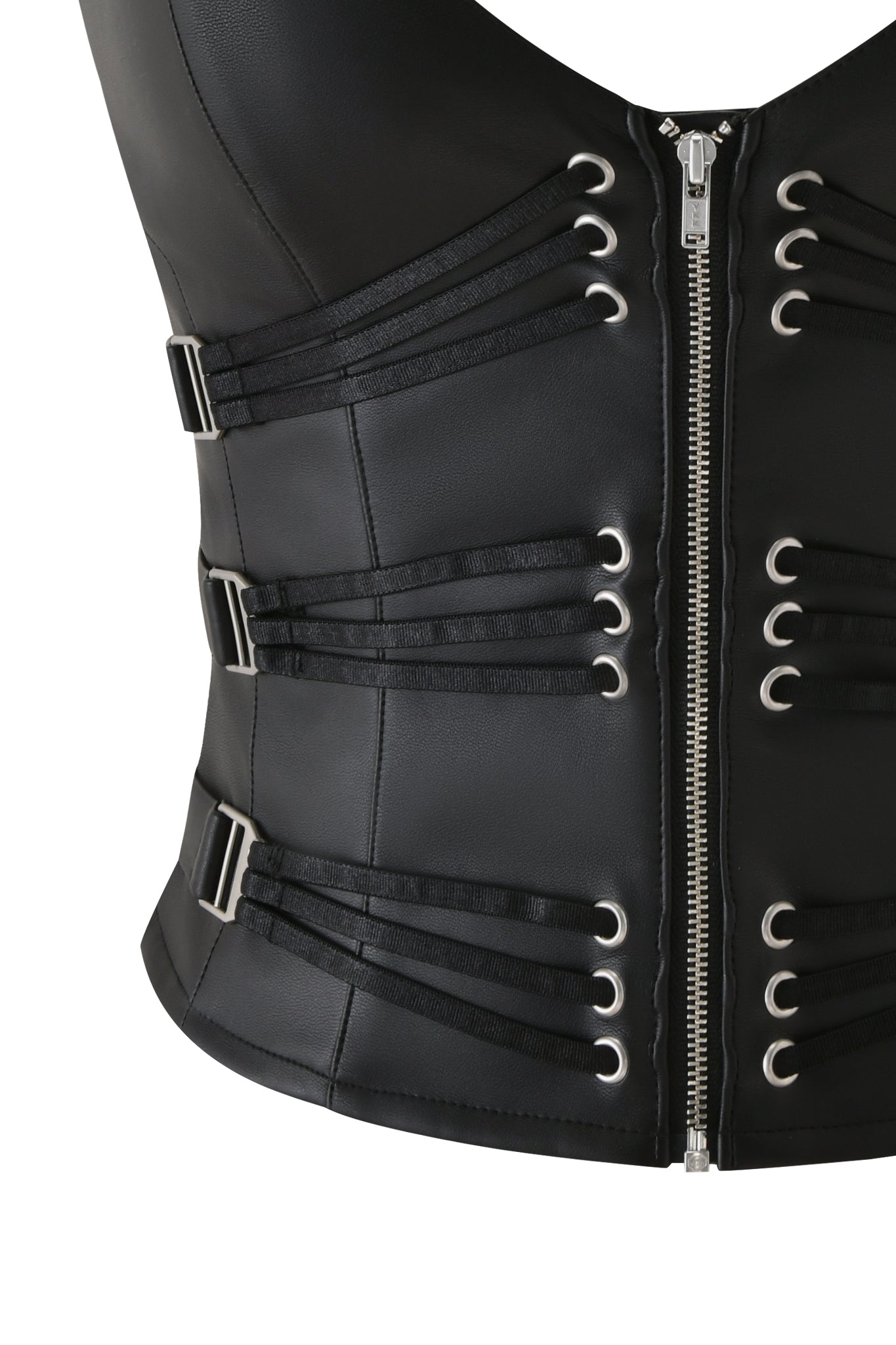 The SIBARI CORSET TOP by I.AM.GIA is a black faux leather racerback corset featuring a silver front zipper, side buckles, and strappy horizontal straps with metal eyelets for a structured, fitted look.