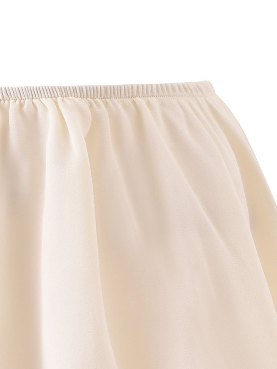 Close-up of the OCEANA CORSET SET - BROWN by I.AM.GIA, featuring a cream-colored, flouncy mini skirt with an elastic waistband, photographed against a plain background.